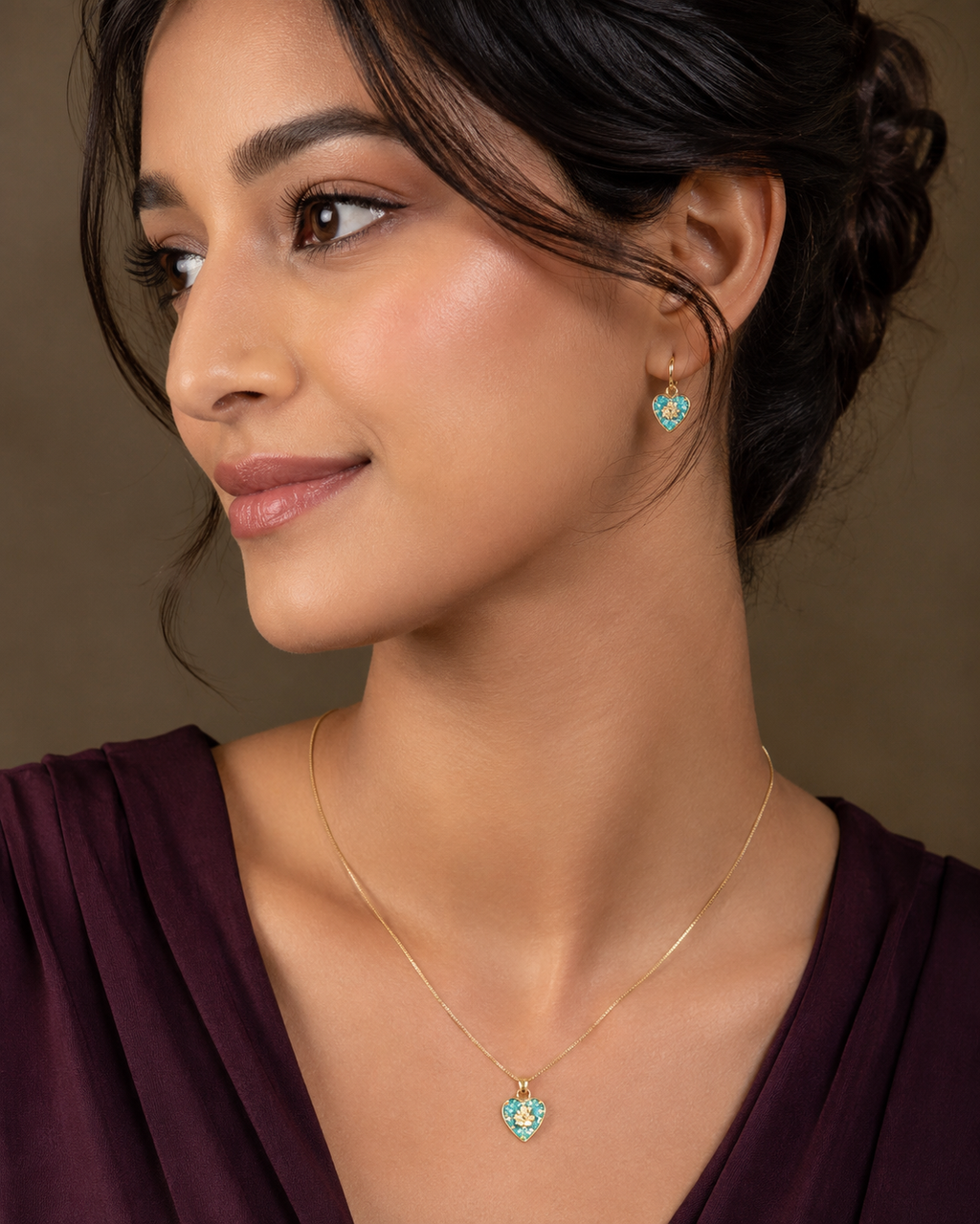 Gold Emerald Pavé Heart Pendant Necklace & Drop Earrings Set worn on model with burgundy silk V-neck top and updo