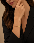 Gold Oval Disc Station Open Cuff Bracelet worn on wrist with black blazer