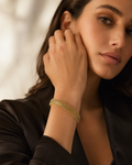 Gold Wide Mesh Tube Bangle Bracelet worn on wrist with black satin blazer