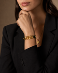 Gold Chunky Curb Chain Black Leather Strap Bracelet worn on wrist with black blazer