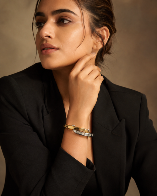Bi-Tone Interlocking Oval Bangle Set worn on wrist with black blazer