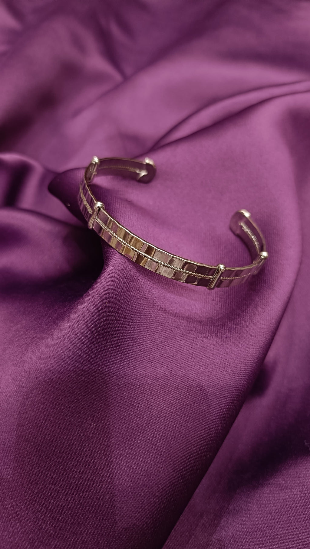 Gold Mirror-Polished Square Tile Open Cuff Bracelet flat lay on purple fabric