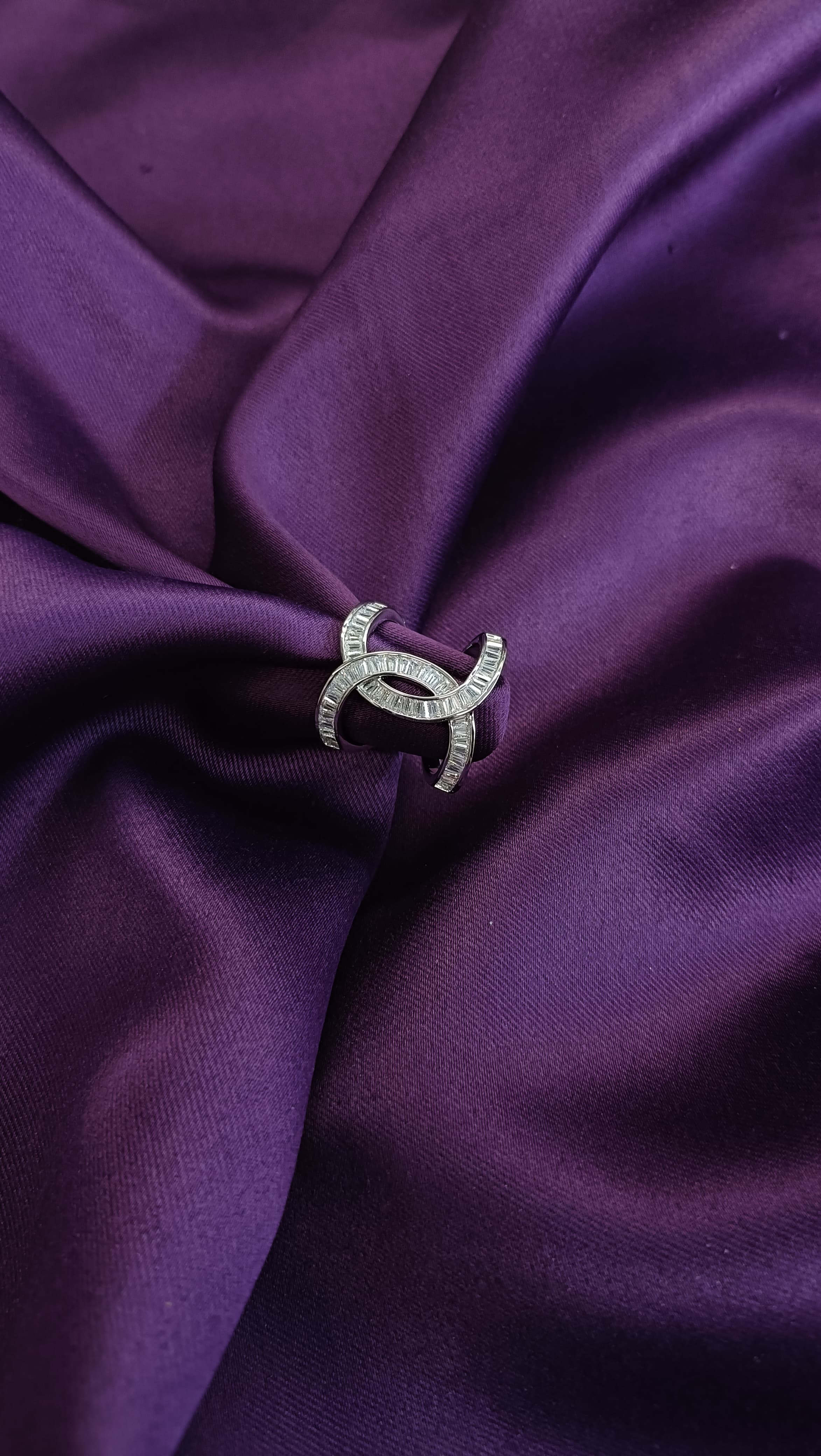 Silver Double Crescent Baguette Crystal Ring flat lay on purple fabric