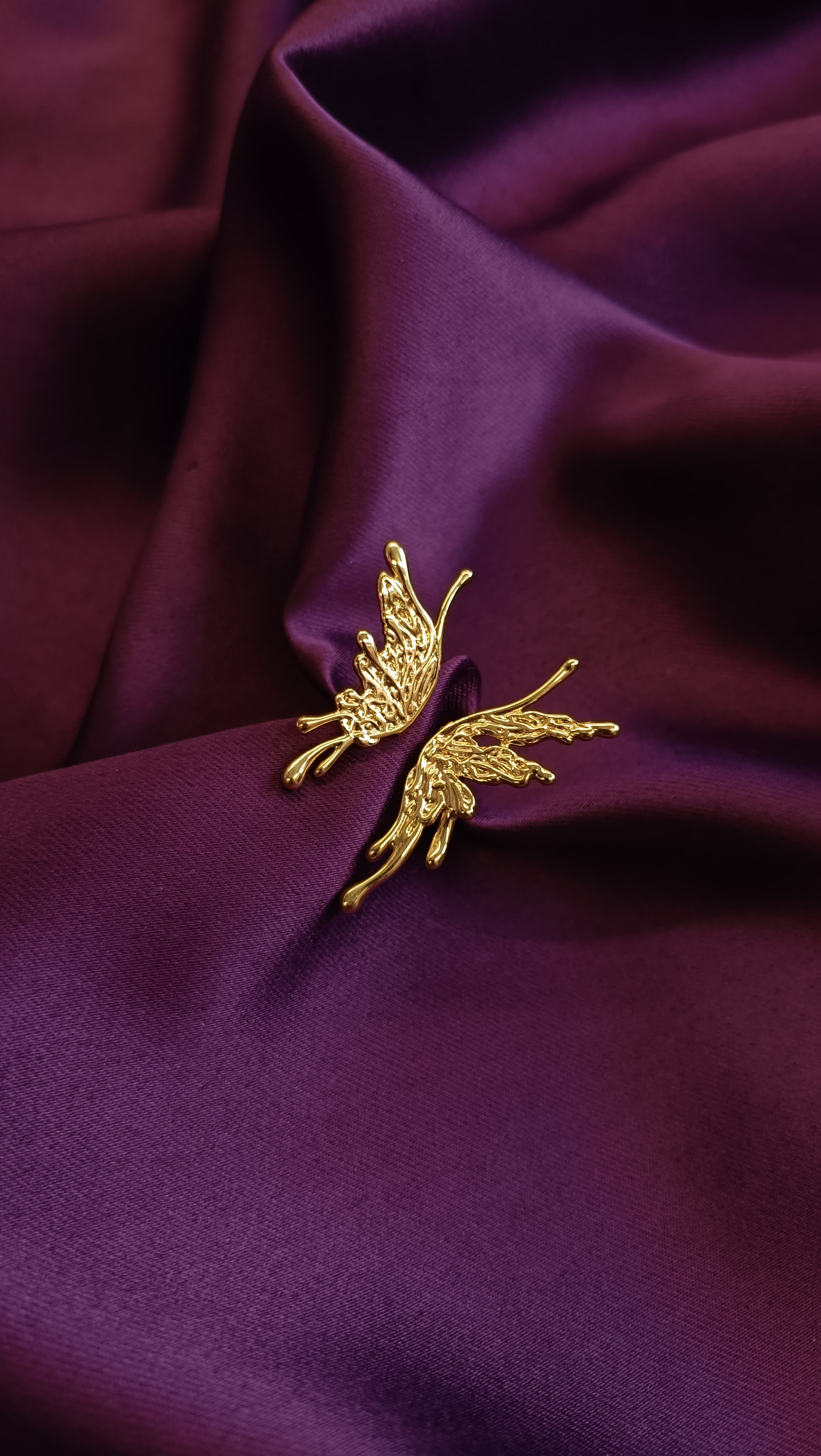 Gold Sculptural Butterfly Open Ring flat lay on purple fabric