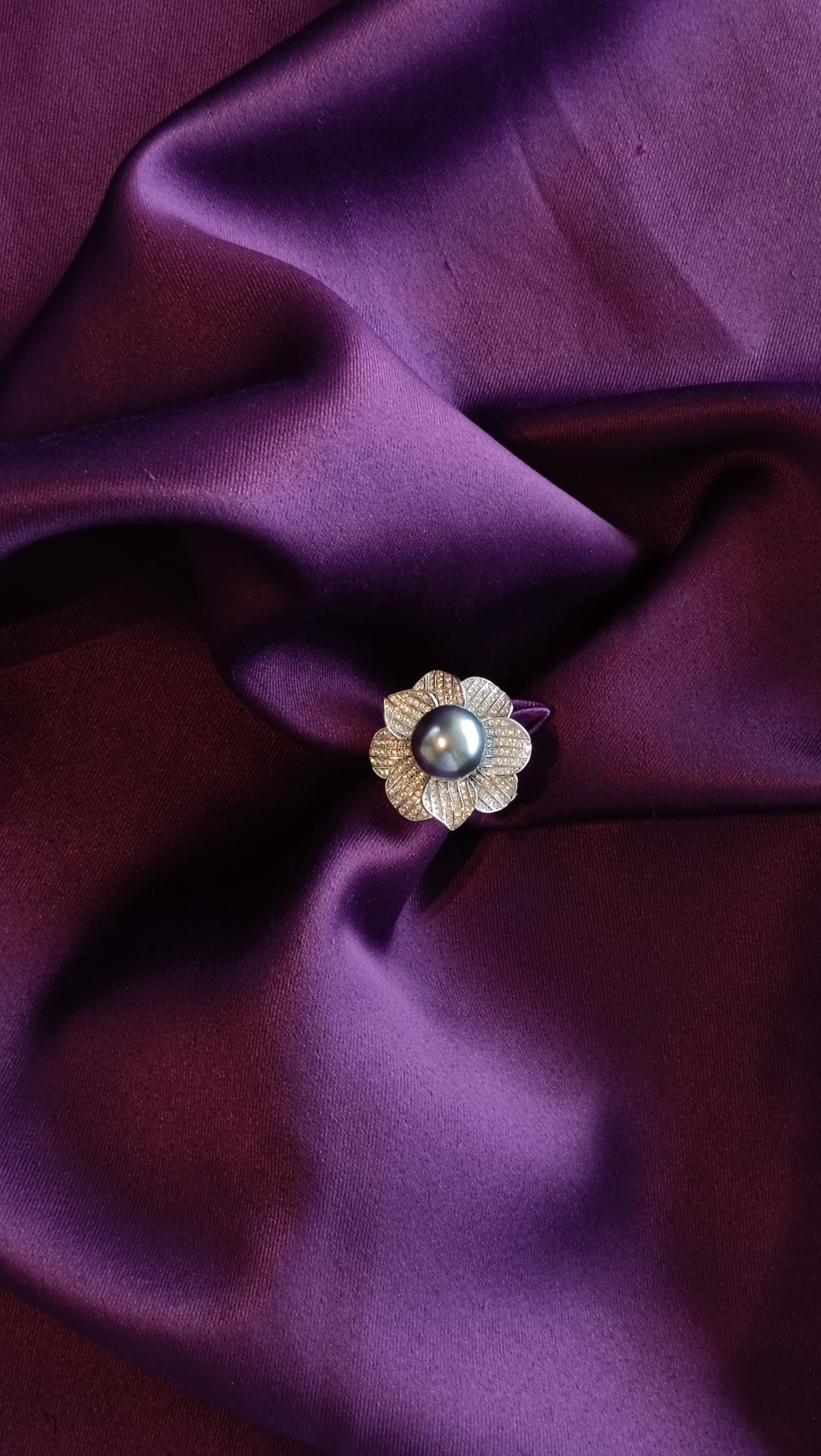 Silver Pavé Floral Ring with Tahitian Pearl Centre flat lay on purple fabric