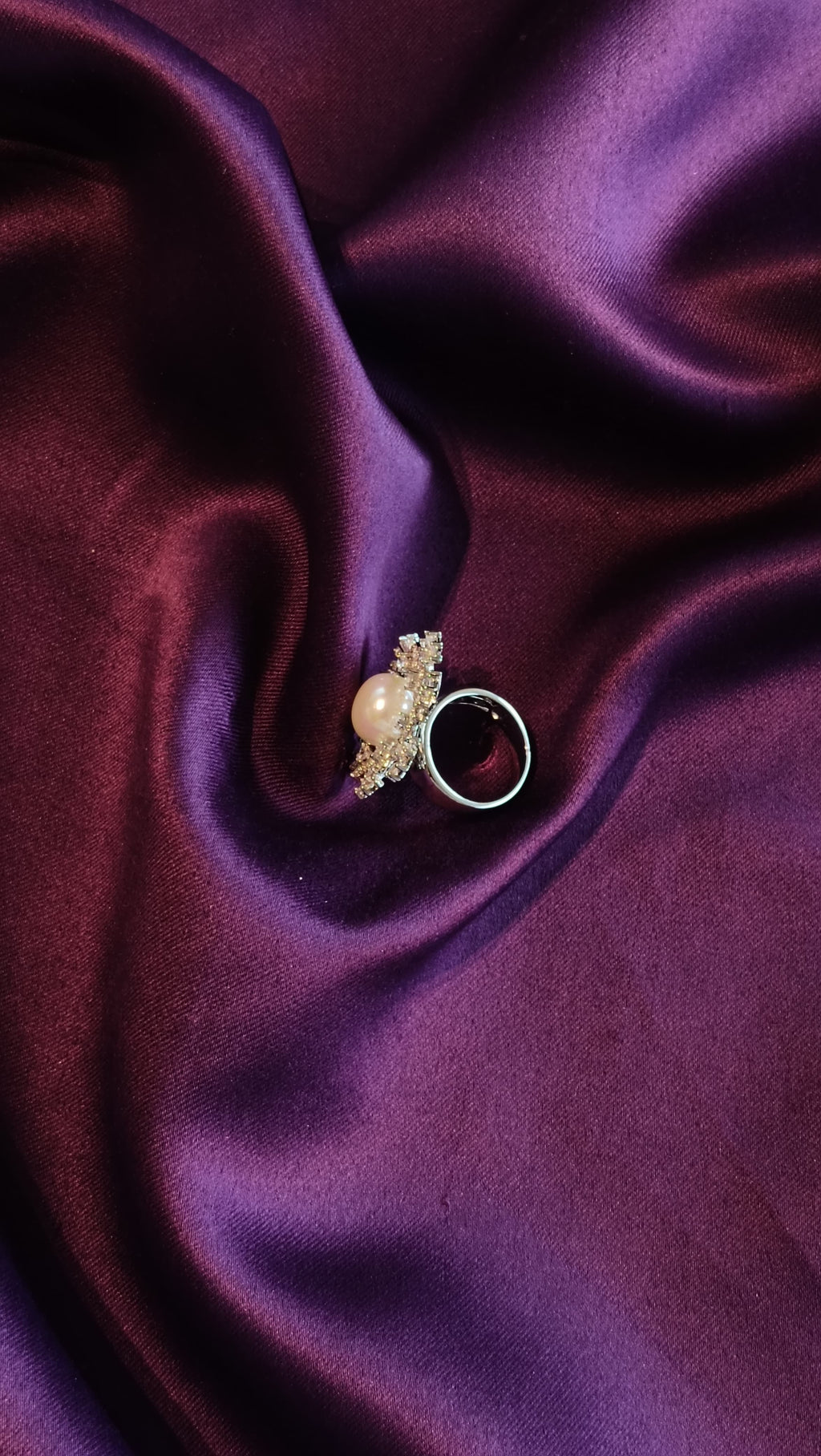Silver Sunburst Floral Ring with Freshwater Pearl side view on purple fabric