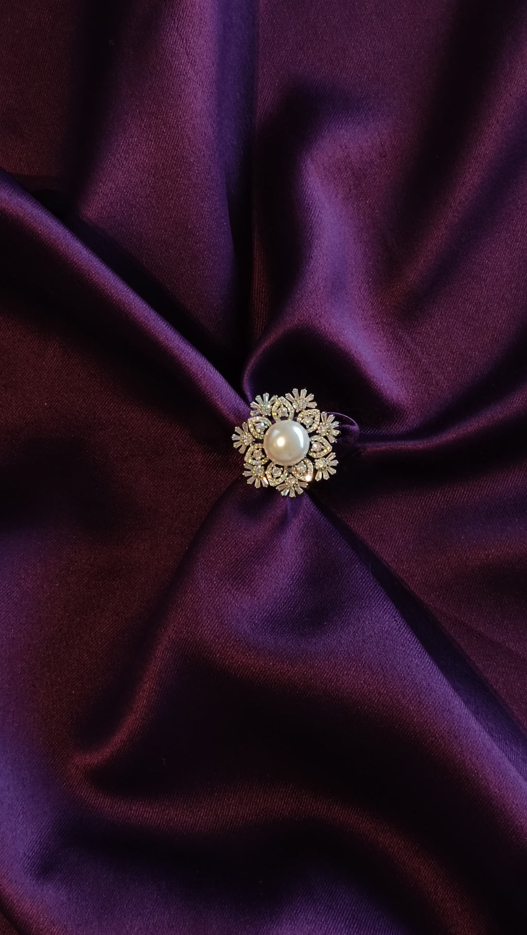 Silver Sunburst Floral Ring with Freshwater Pearl top view on purple fabric