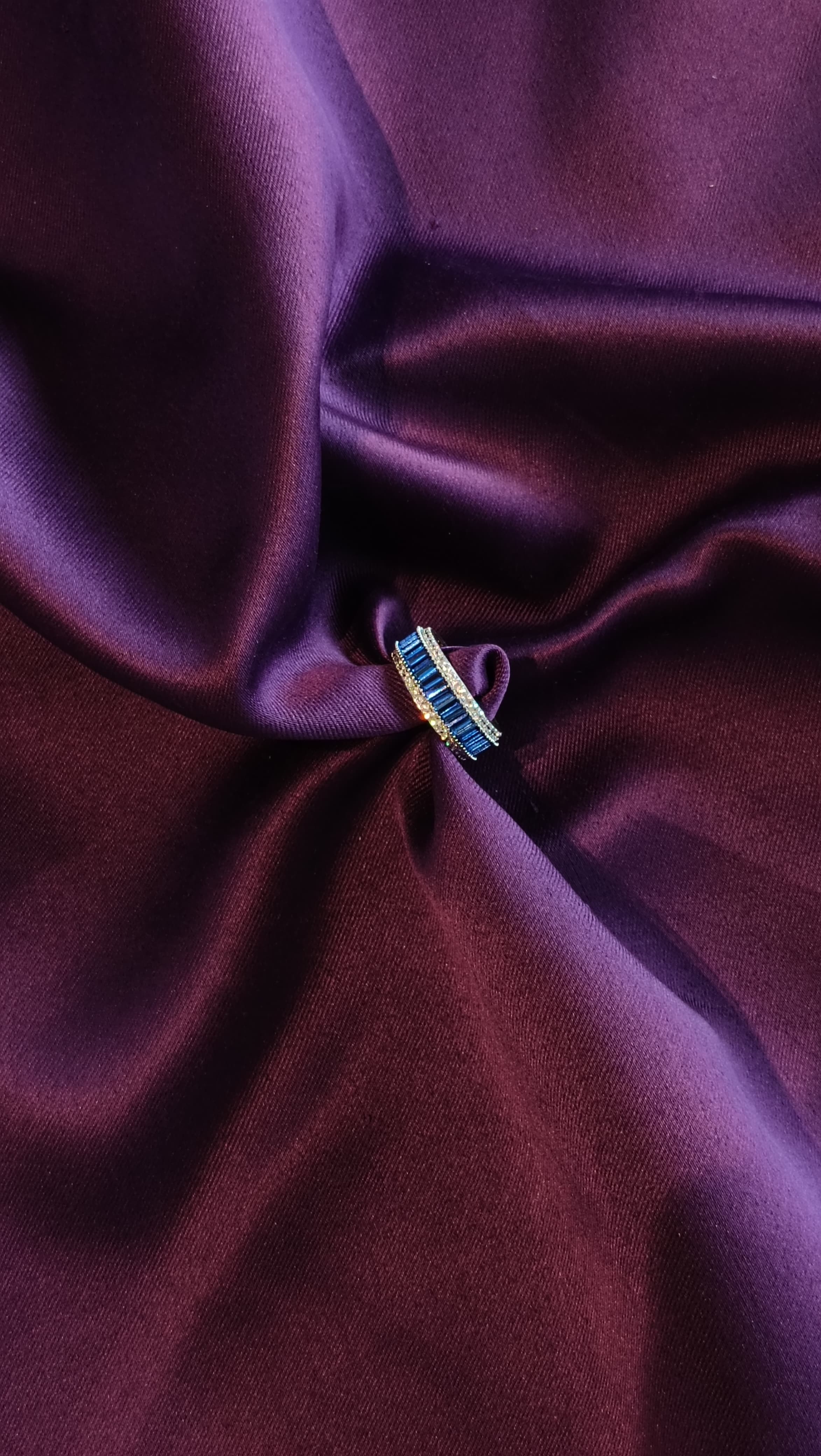 Sapphire Blue Baguette Eternity Band side view on purple fabric