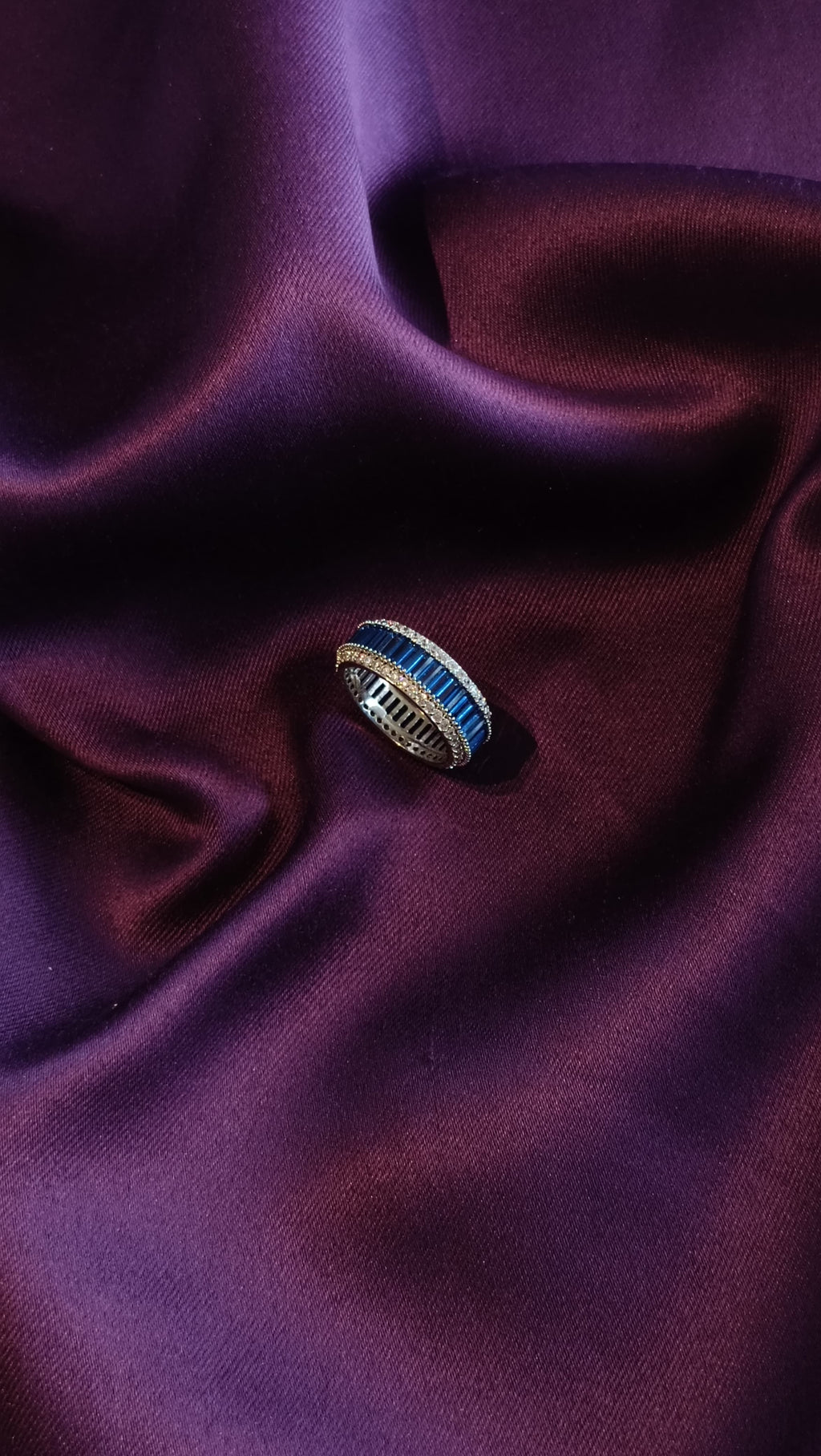 Sapphire Blue Baguette Eternity Band top view on purple fabric