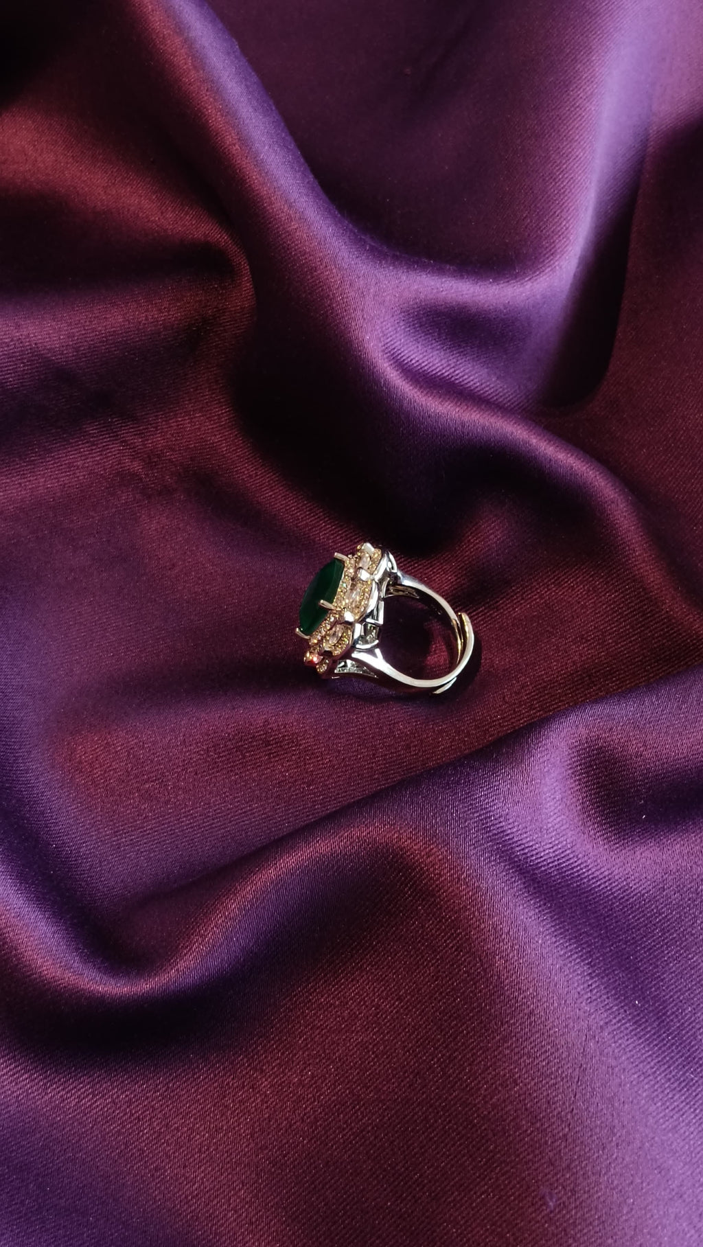 Silver Double Halo Emerald Green Cushion Ring side view on purple fabric