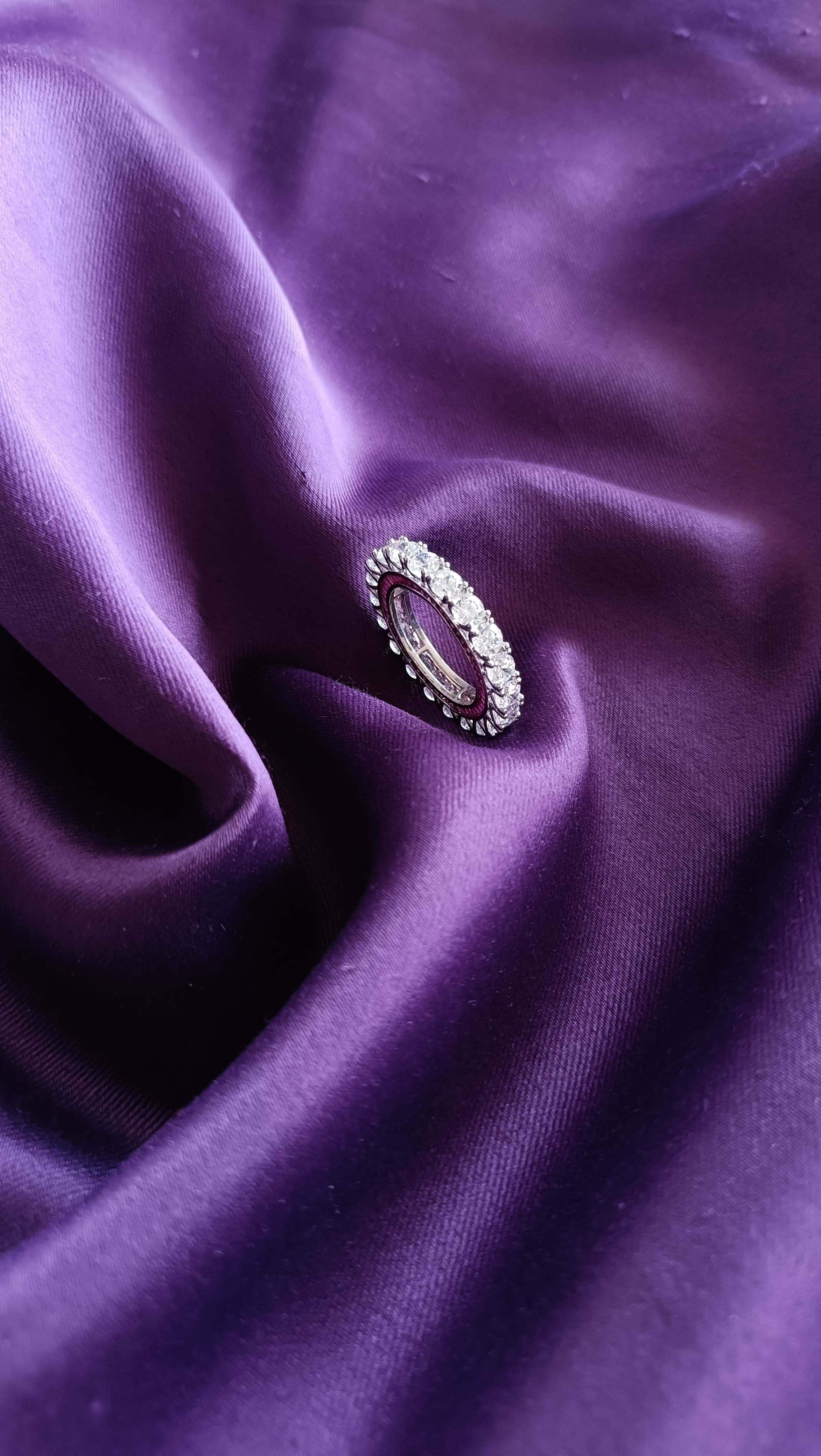 Diamond Eternity Band with Ruby Accent on purple fabric side view