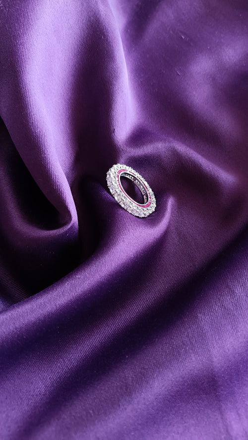Diamond Eternity Band with Ruby Accent on purple fabric close-up