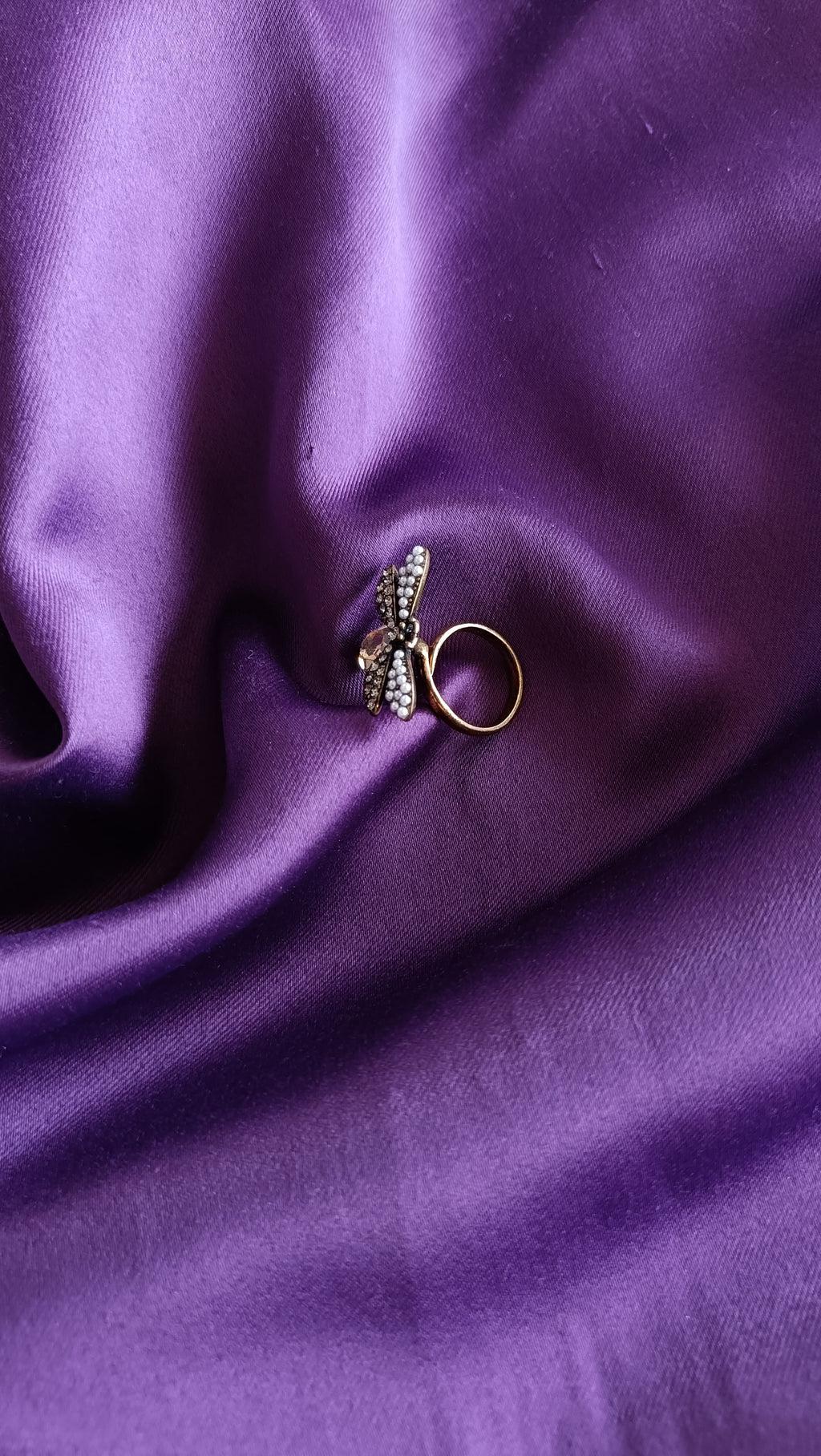 Gunmetal Bee Ring flat lay on purple fabric