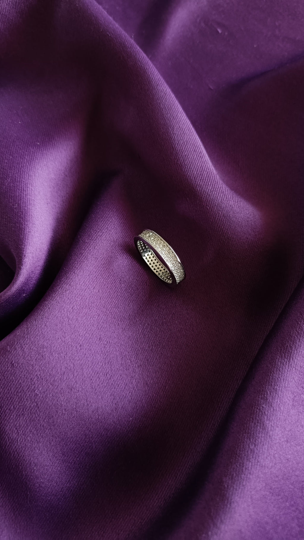 Double Row Pavé Crystal Band Ring flat lay on purple fabric