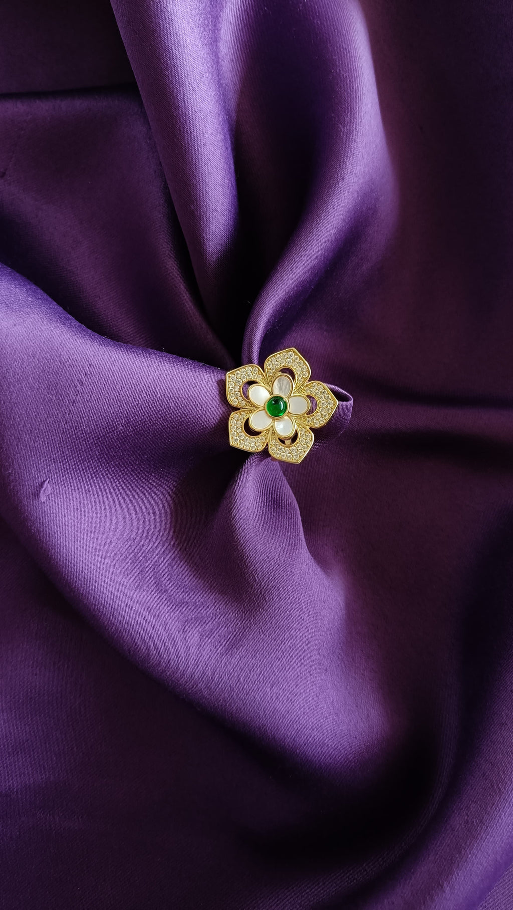 Gold Floral Ring flat lay on purple fabric