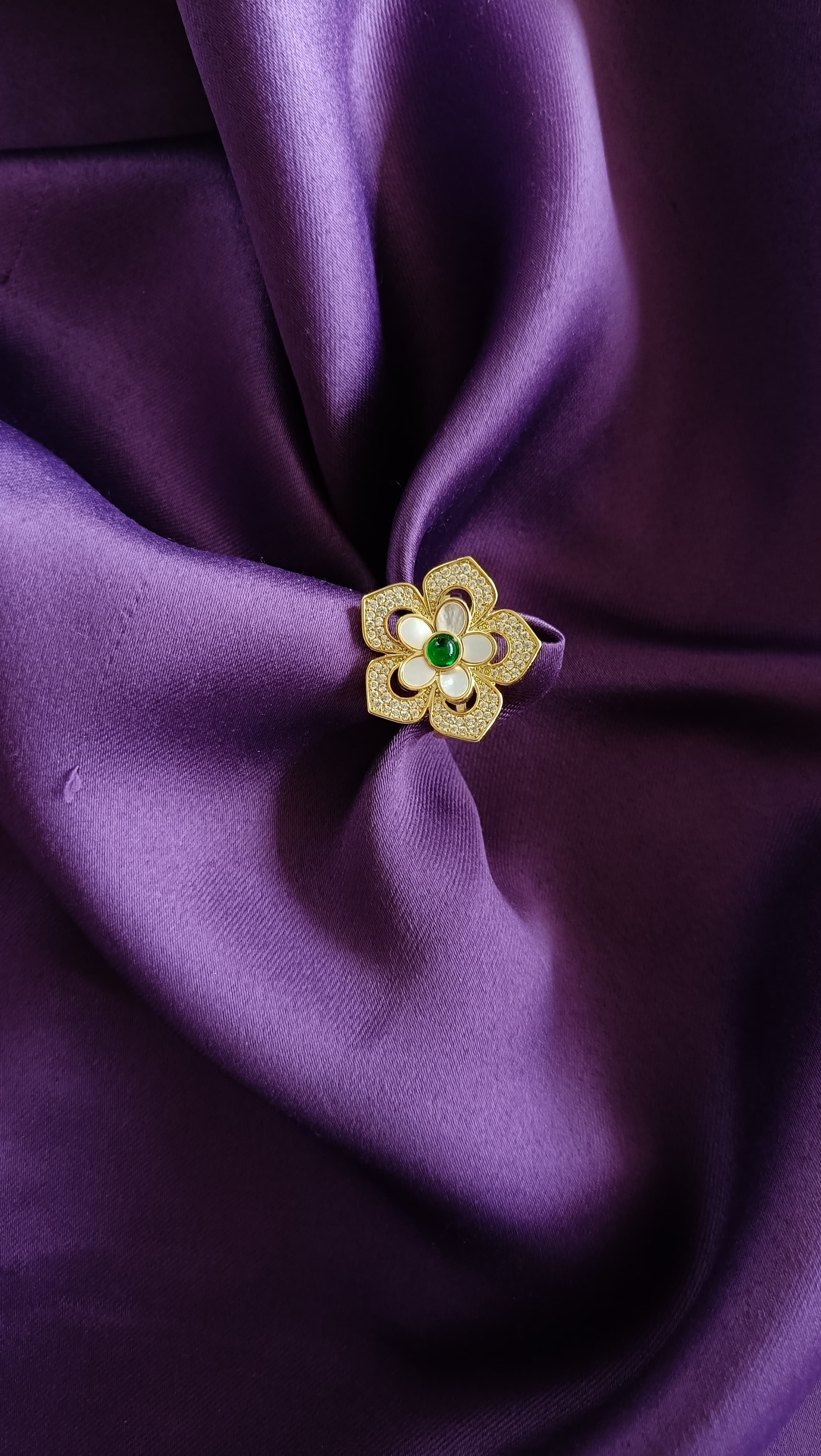 Gold Floral Ring flat lay on purple fabric