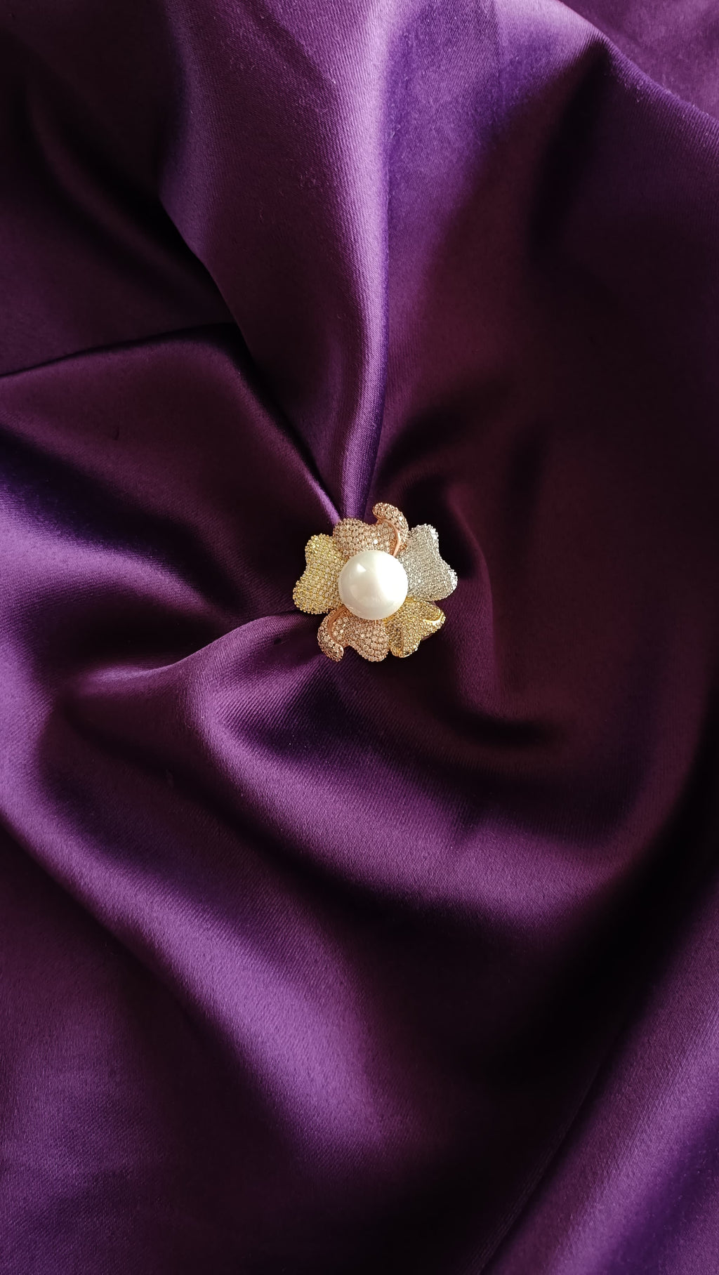 Tri-Tone Pavé Floral Ring with Freshwater Pearl flat lay on purple fabric