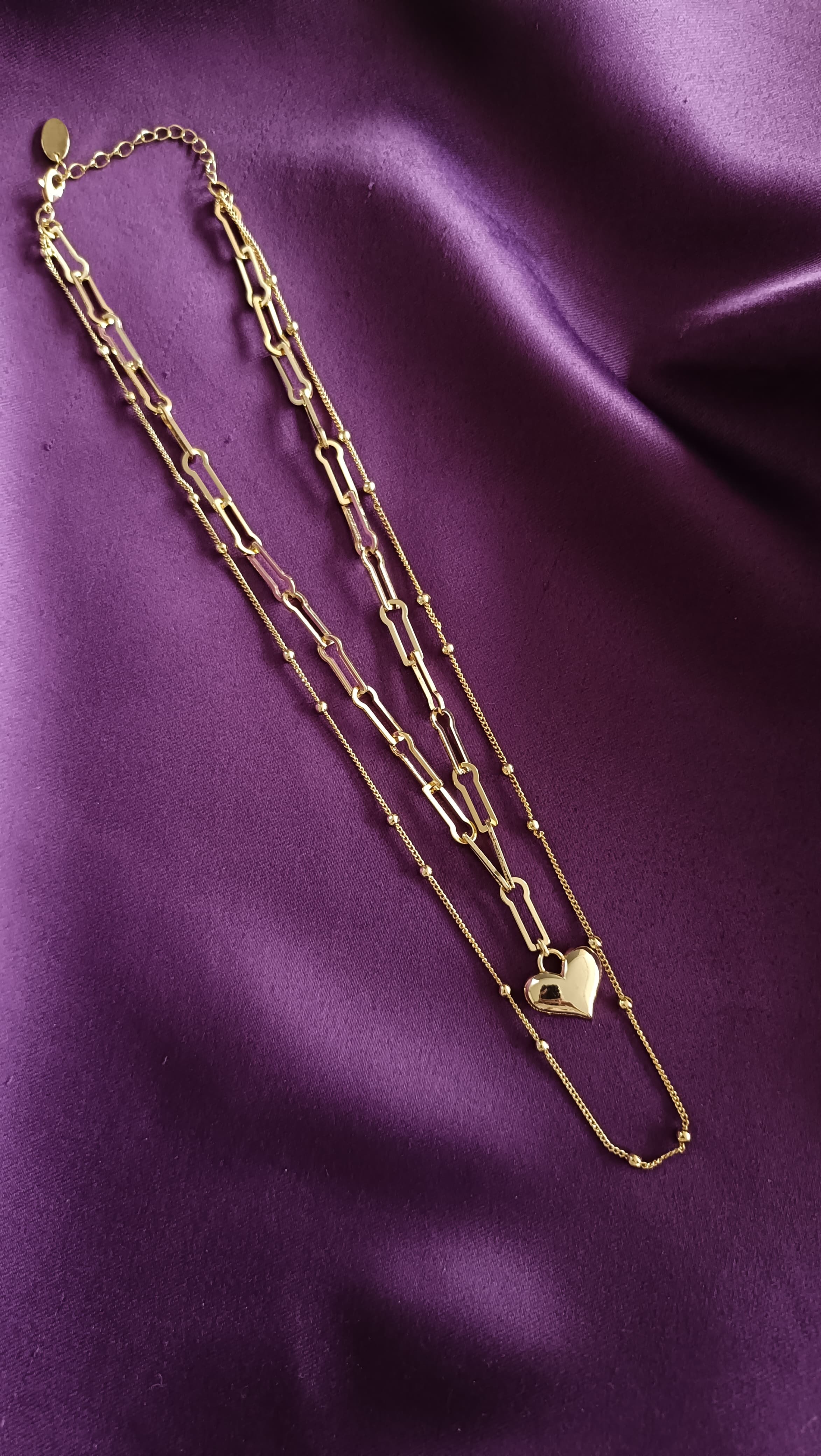 Gold Double-Layer Heart Pendant Necklace Set full length flat lay on purple fabric