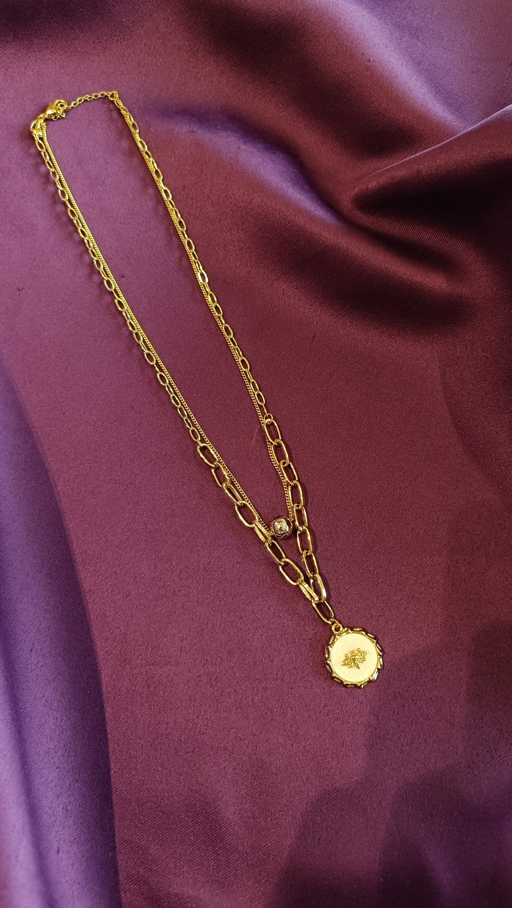 Gold Double-Layer Paperclip Chain Bee Medallion Necklace full length flat lay on purple fabric