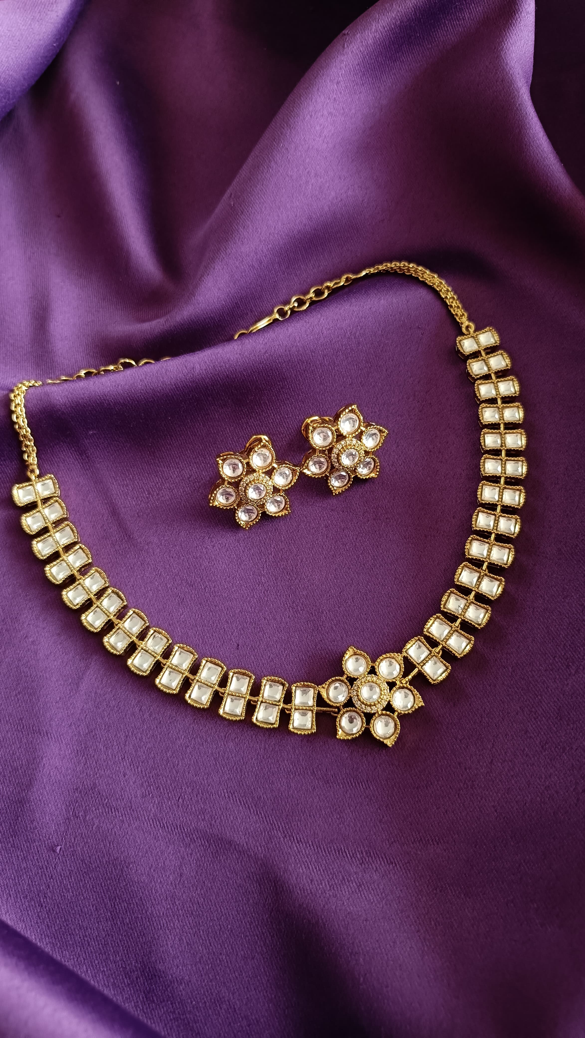 Gold Floral Kundan Polki Stud Earrings front and back detail flat lay on purple fabric