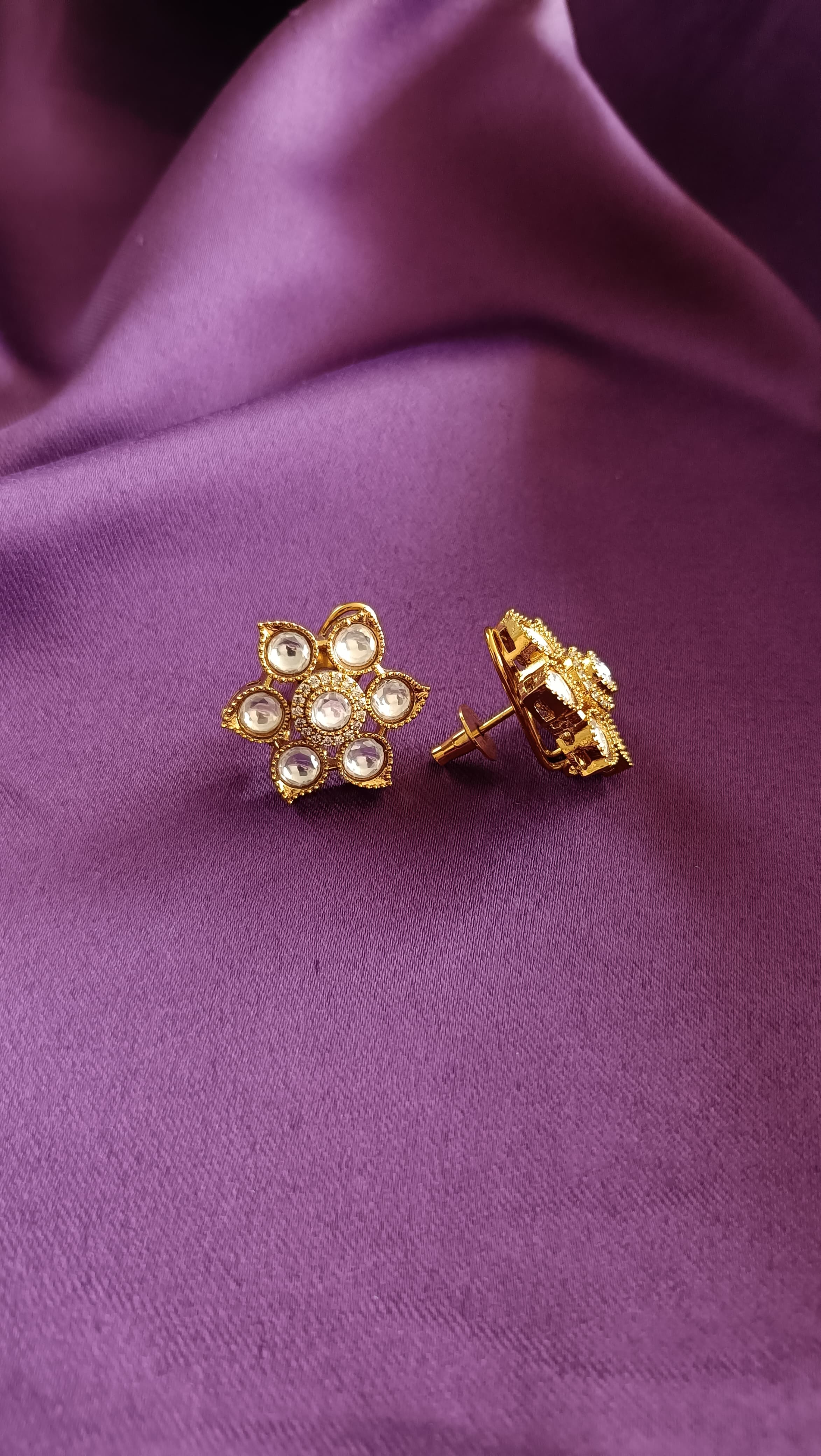 Gold Floral Kundan Polki Stud Earrings pair flat lay on purple fabric