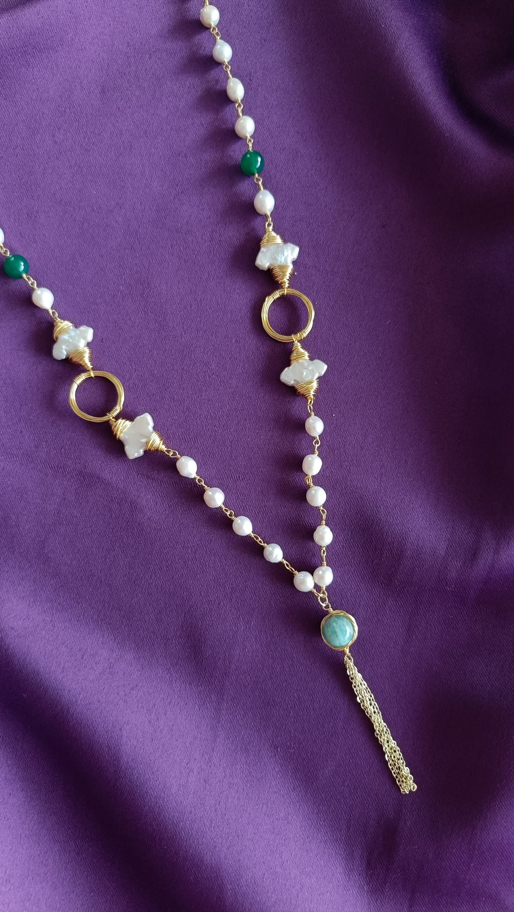 Gold Wire-Wrapped Mother-of-Pearl Flower & Green Onyx Long Lariat Necklace centre detail flat lay on purple fabric showing MOP flowers, open rings and chalcedony tassel