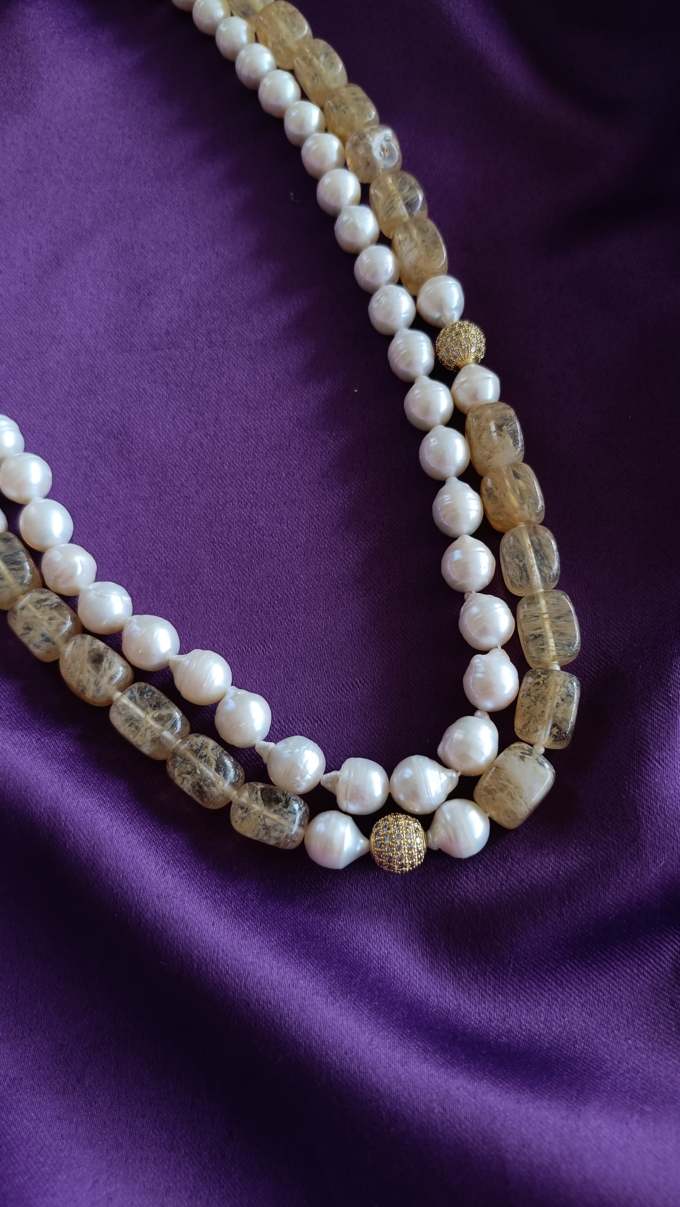 Gold Double-Strand Freshwater Pearl & Rutilated Quartz Necklace centre detail close-up flat lay on purple fabric showing pavé ball stations
