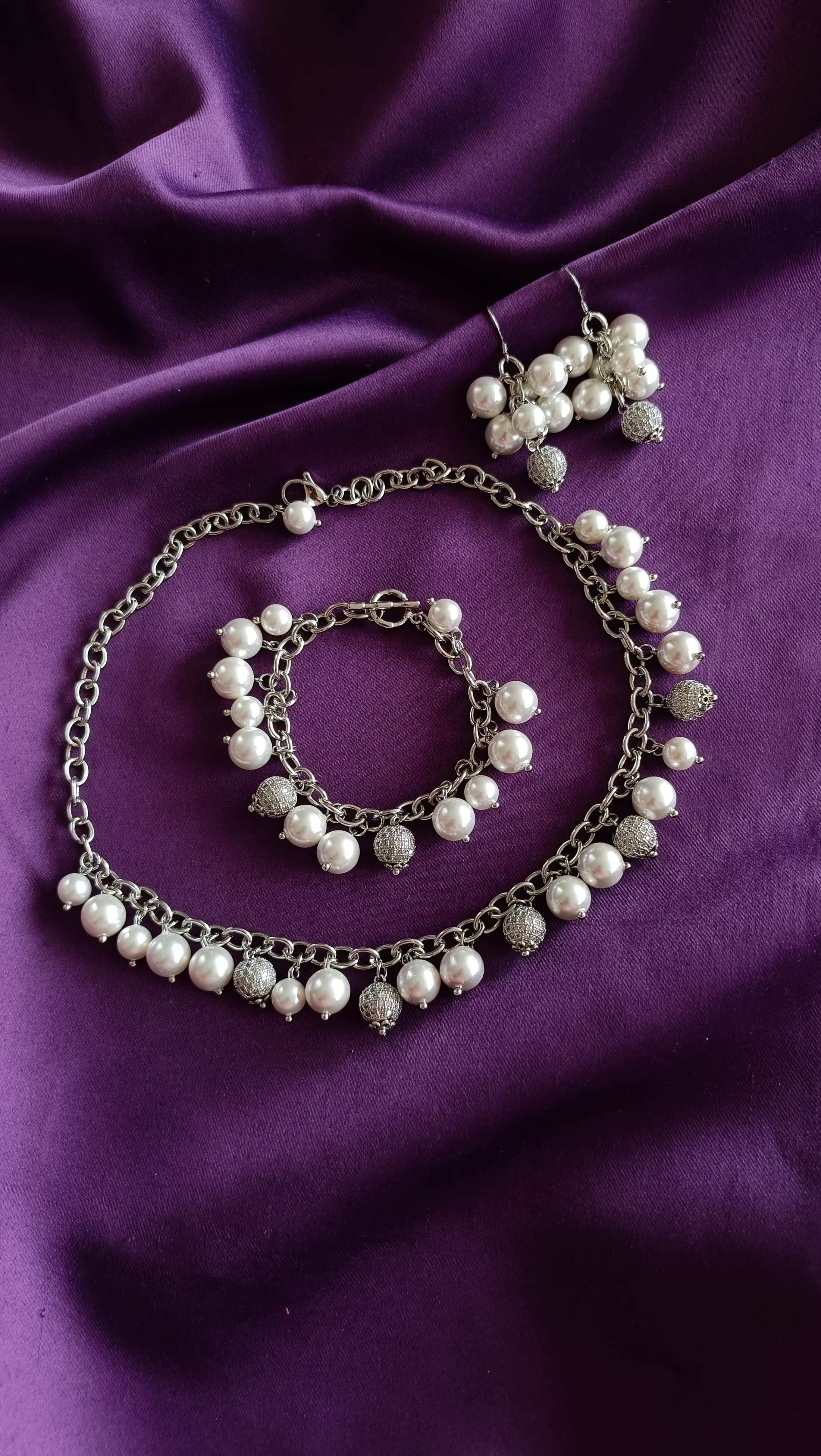 Silver Pearl & Pavé Ball Charm Choker, Cluster Drop Earrings & Charm Bracelet full set flat lay on purple fabric