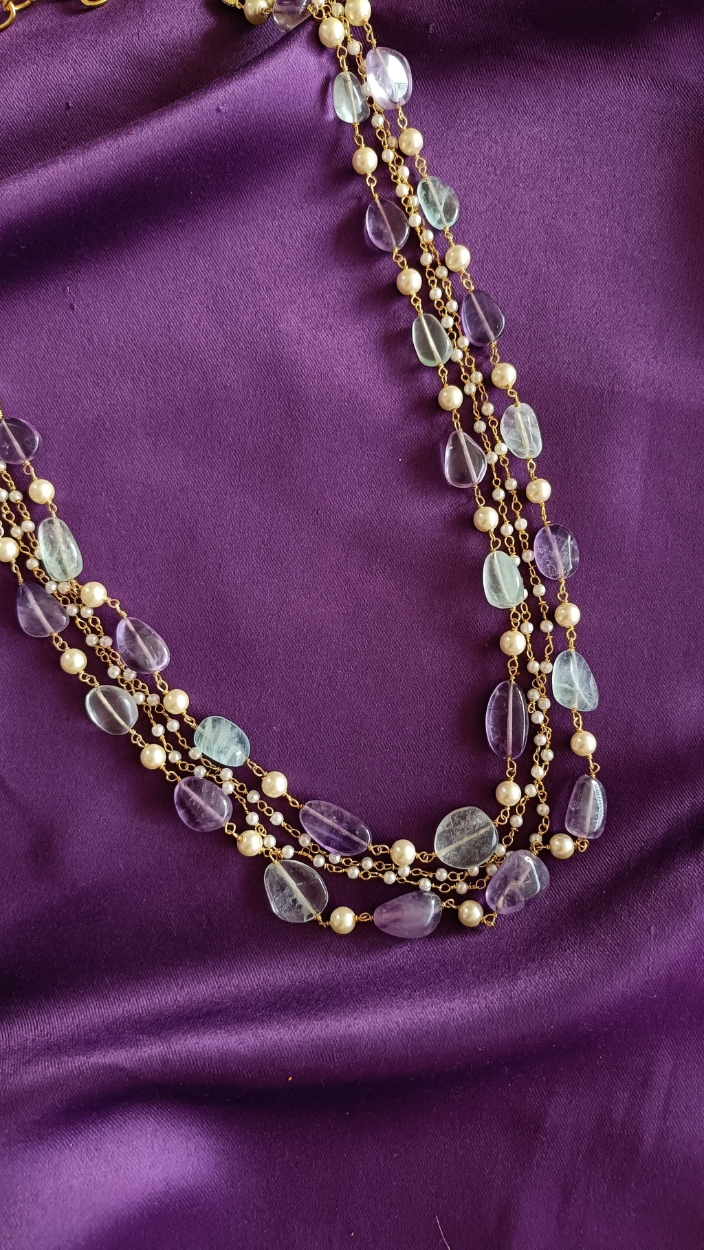 Gold Five-Strand Fluorite Tumbled Bead & Pearl Chain Necklace centre detail close-up flat lay on purple fabric