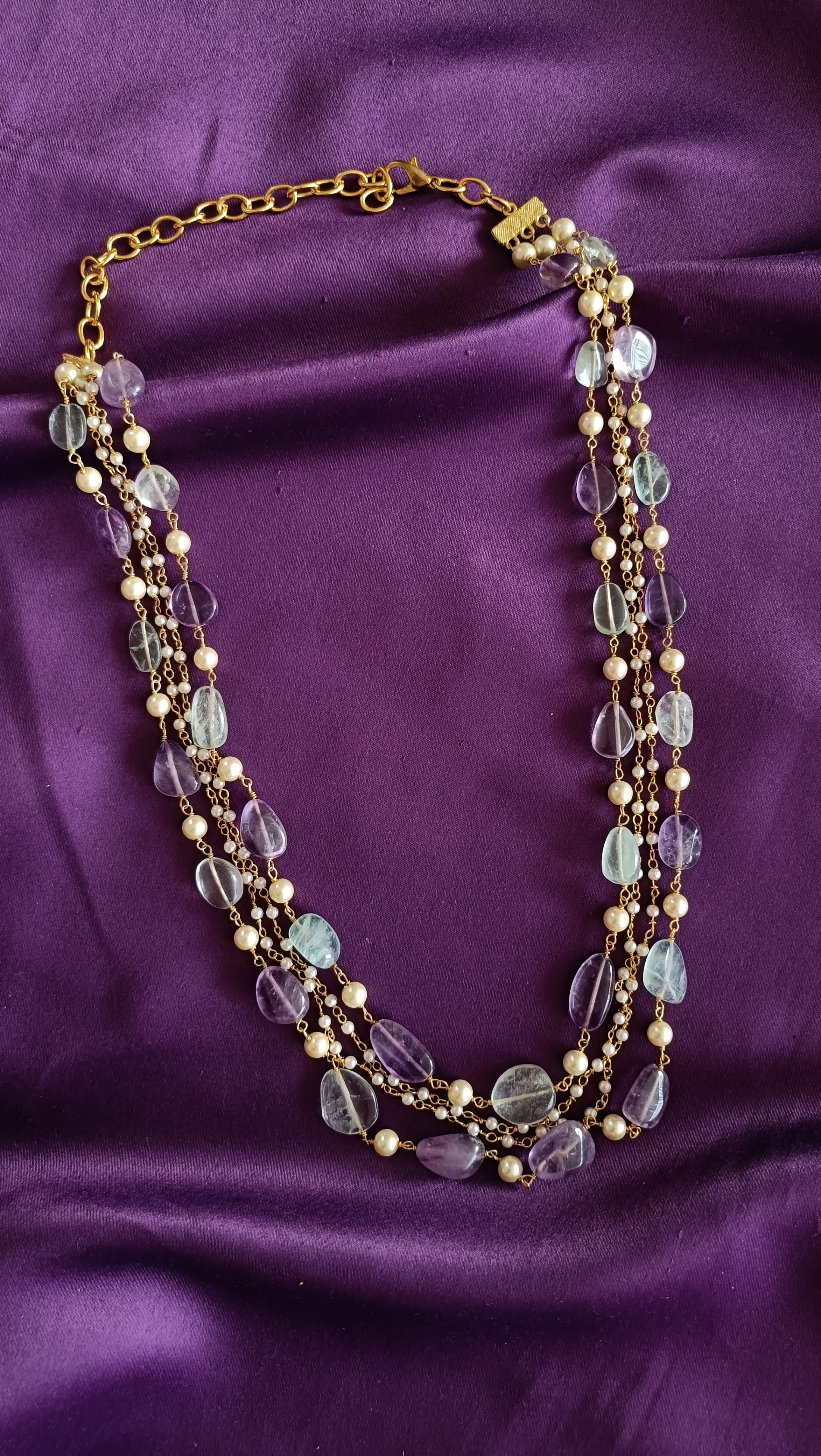 Gold Five-Strand Fluorite Tumbled Bead & Pearl Chain Necklace full length flat lay on purple fabric