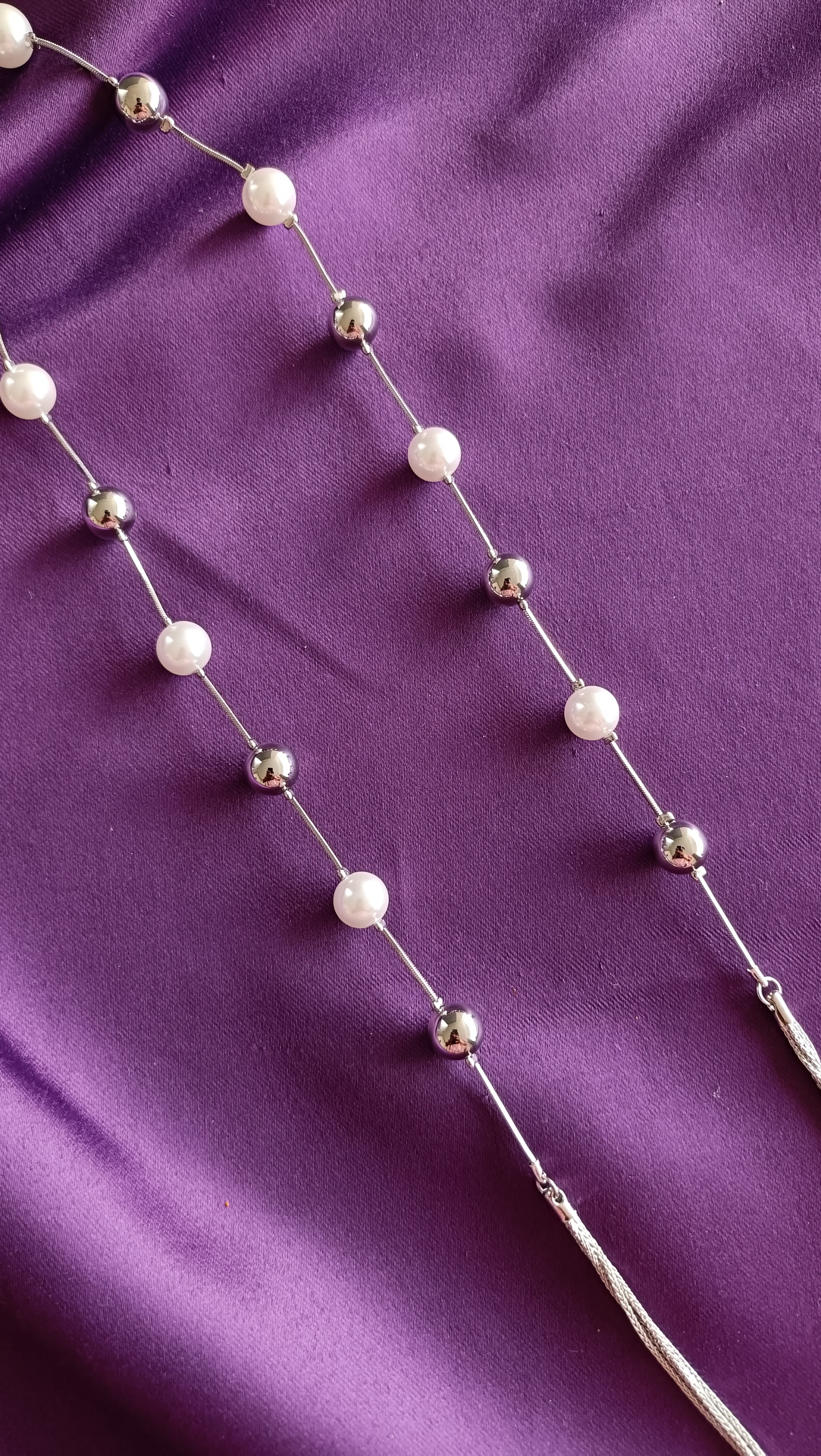 Silver Pearl & Ball Station Long Tassel Chain Necklace pearl station detail flat lay on purple fabric