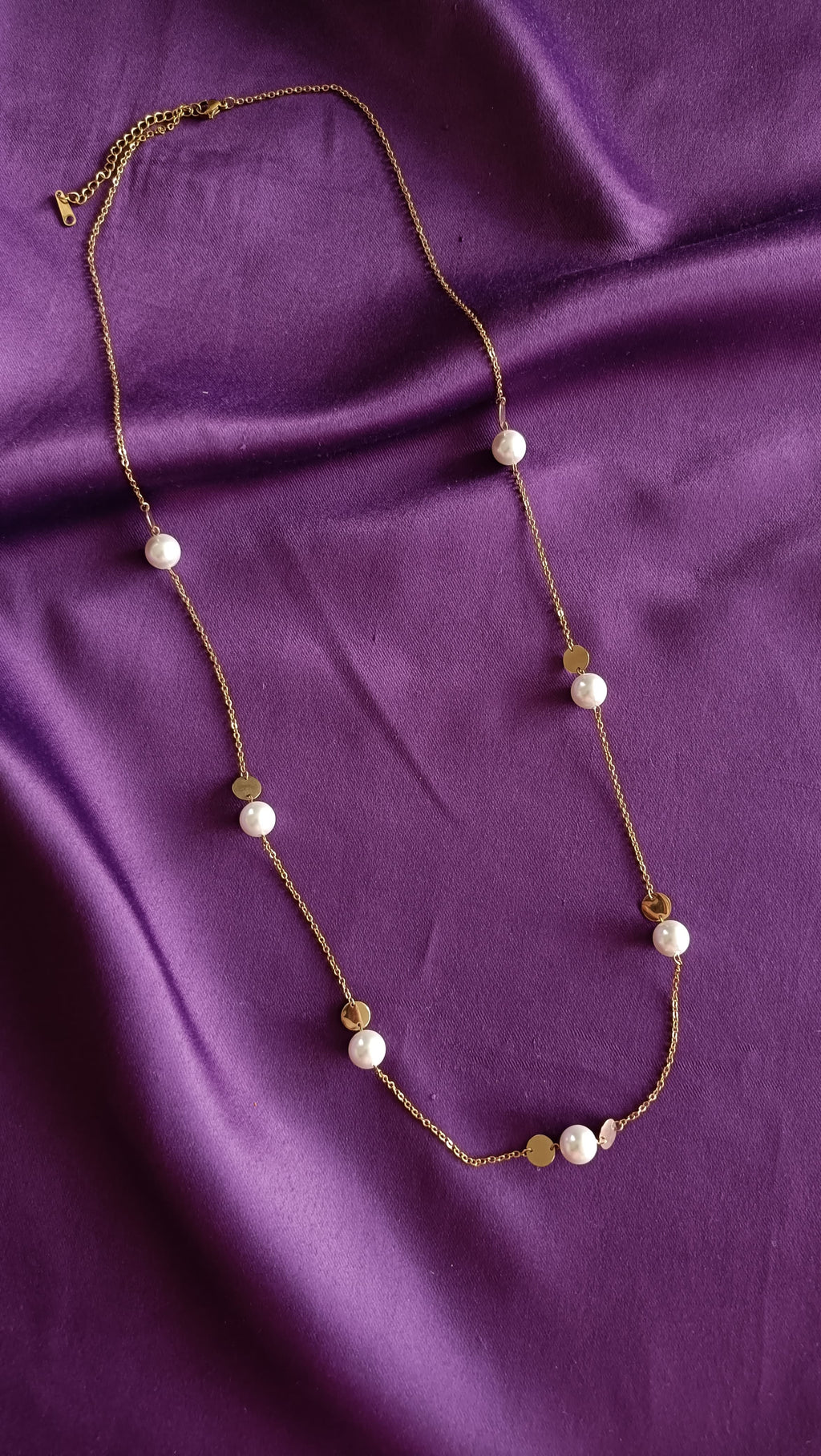 Gold Pearl & Coin Disc Station Long Necklace full length flat lay on purple fabric