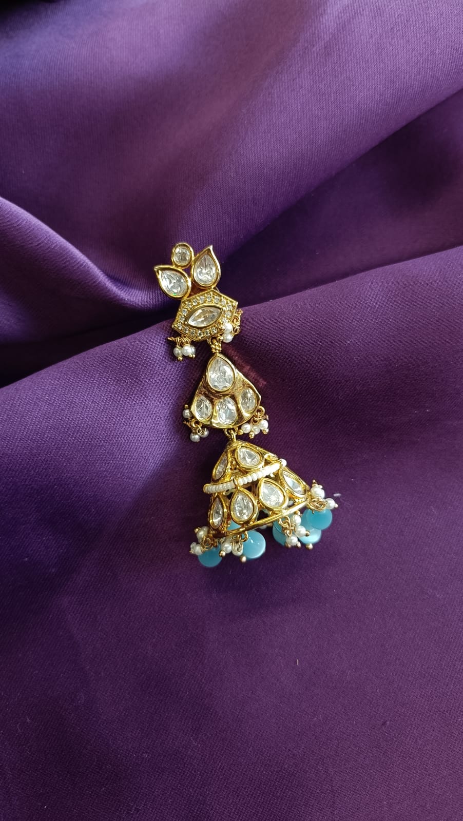 Gold Kundan Polki Three-Tier Jhumka Earring single side view flat lay on purple fabric showing three tiers and aqua drops