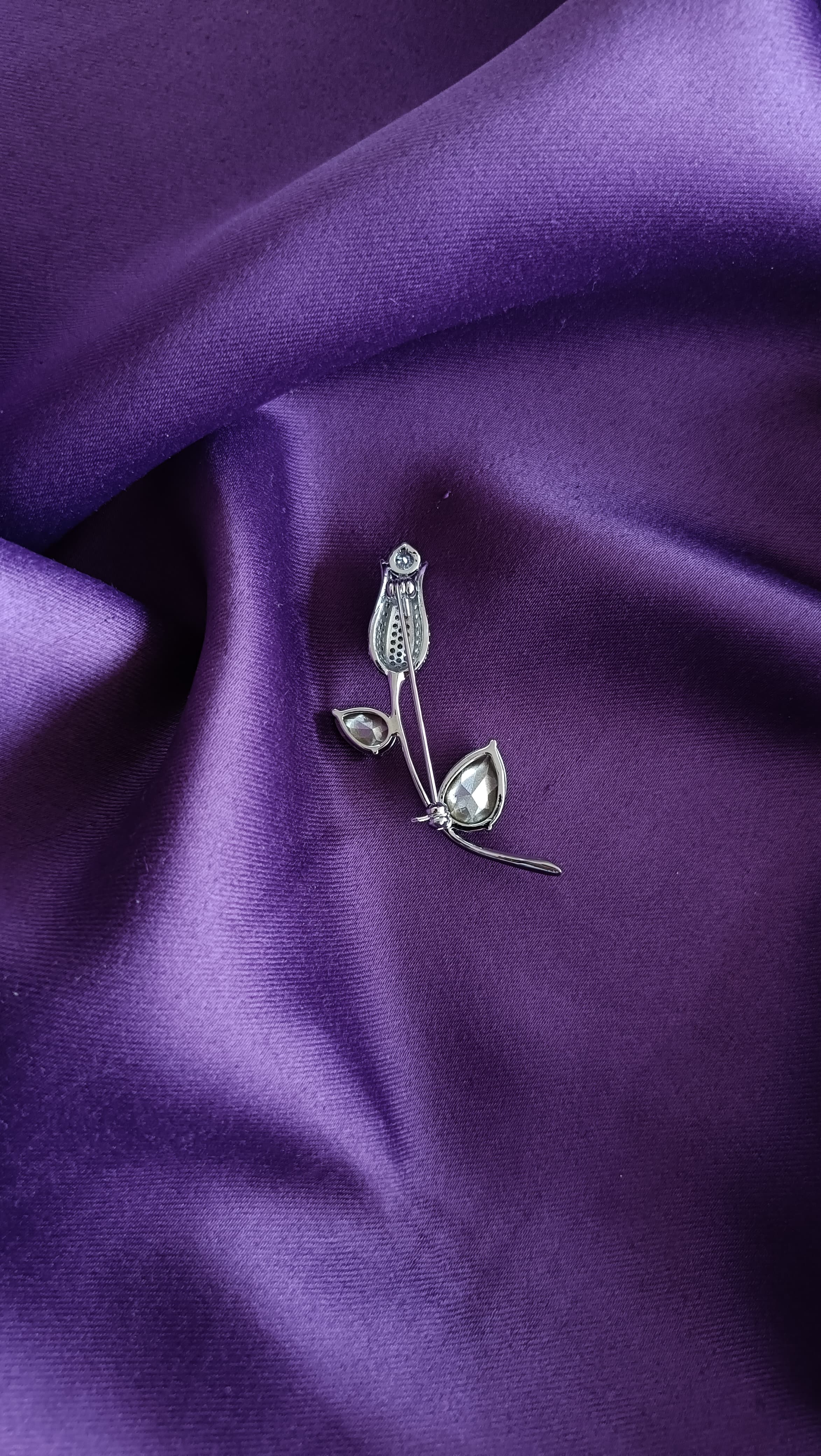 Silver Emerald Crystal Tulip Bud & Leaf Lapel Brooch Pin reverse side flat lay on purple fabric showing pin back closure and stem detail