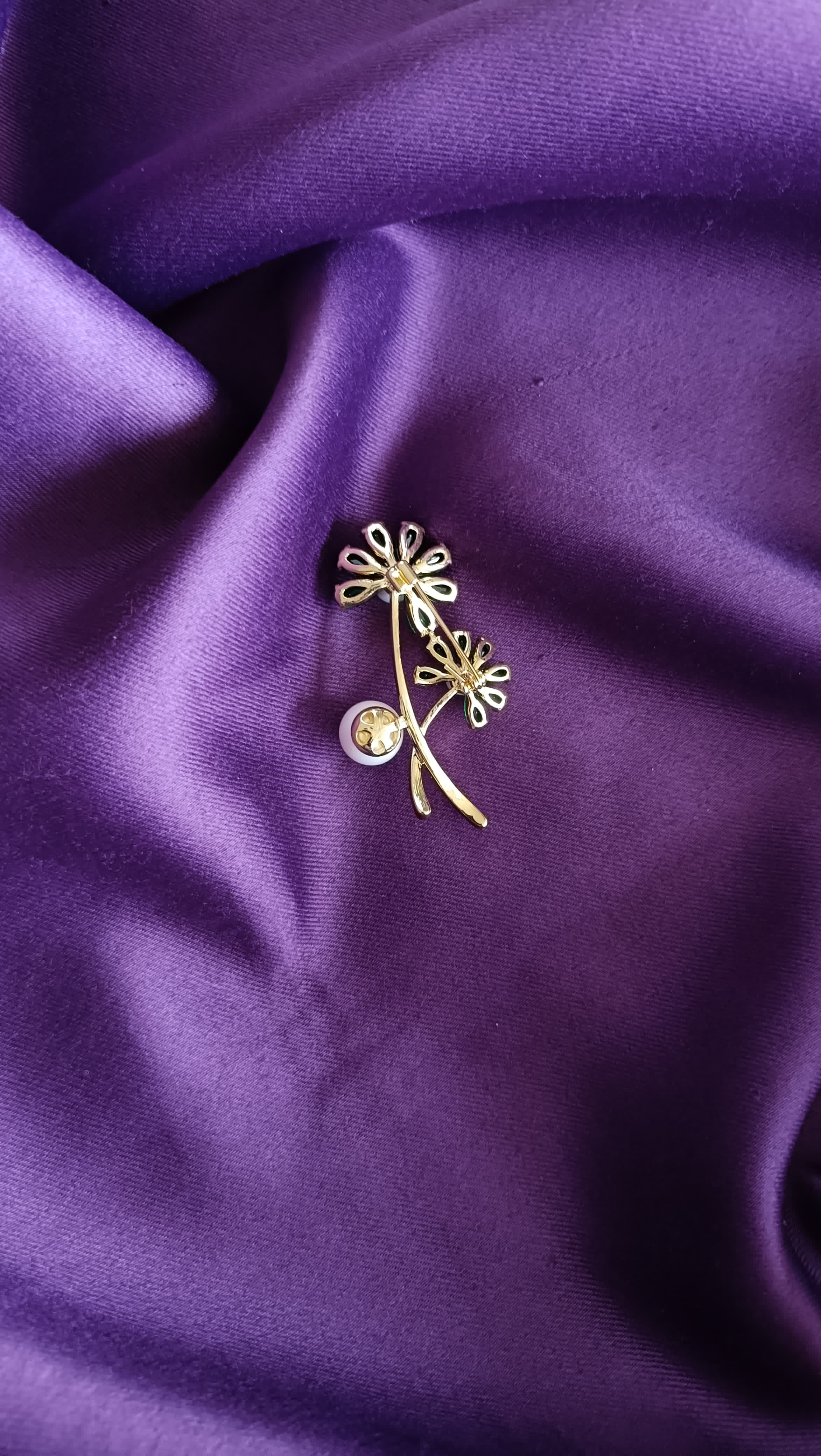 Gold Emerald Crystal Daisy Double Bloom & Pearl Lapel Brooch Pin reverse side flat lay on purple fabric showing gold twig stem and pin back closure