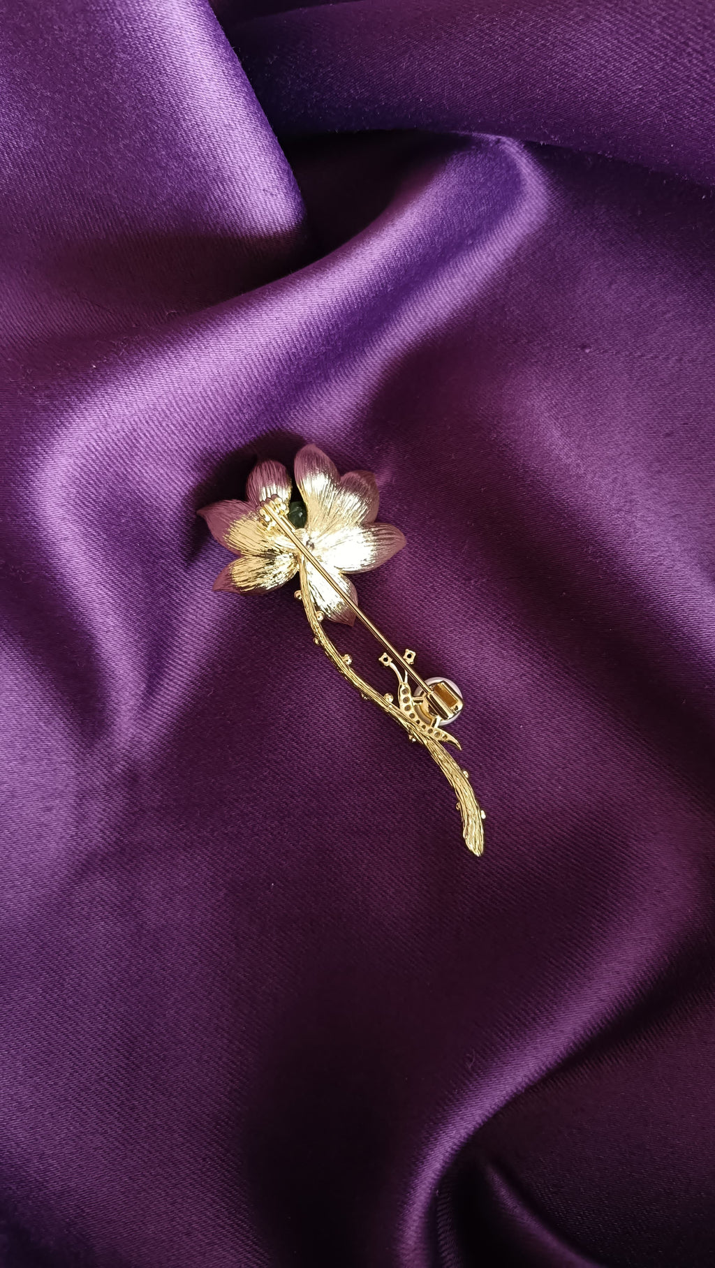Gold Deep Blue Enamel Lotus Bloom Long Stem Lapel Brooch Pin reverse side flat lay on purple fabric showing gold botanical twig stem detail and pin back closure