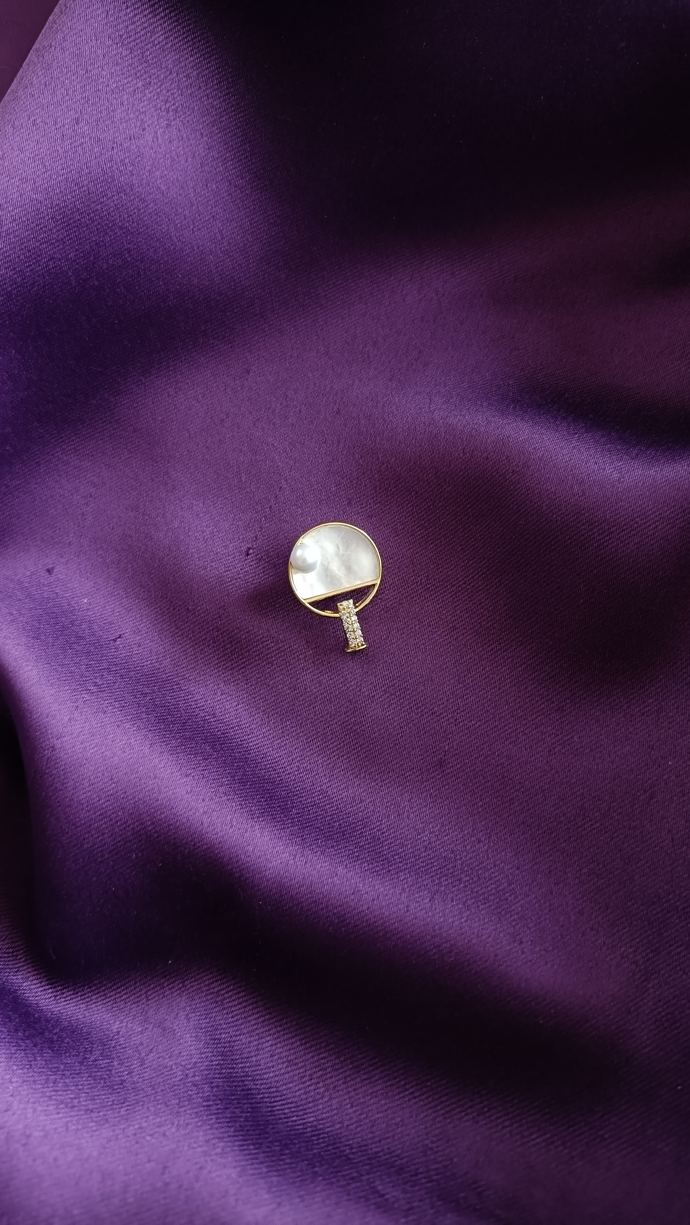 Gold Mother-of-Pearl Round Disc & Pavé Bar Lapel Brooch Pin front view flat lay on purple fabric showing MOP disc and pavé bar handle detail