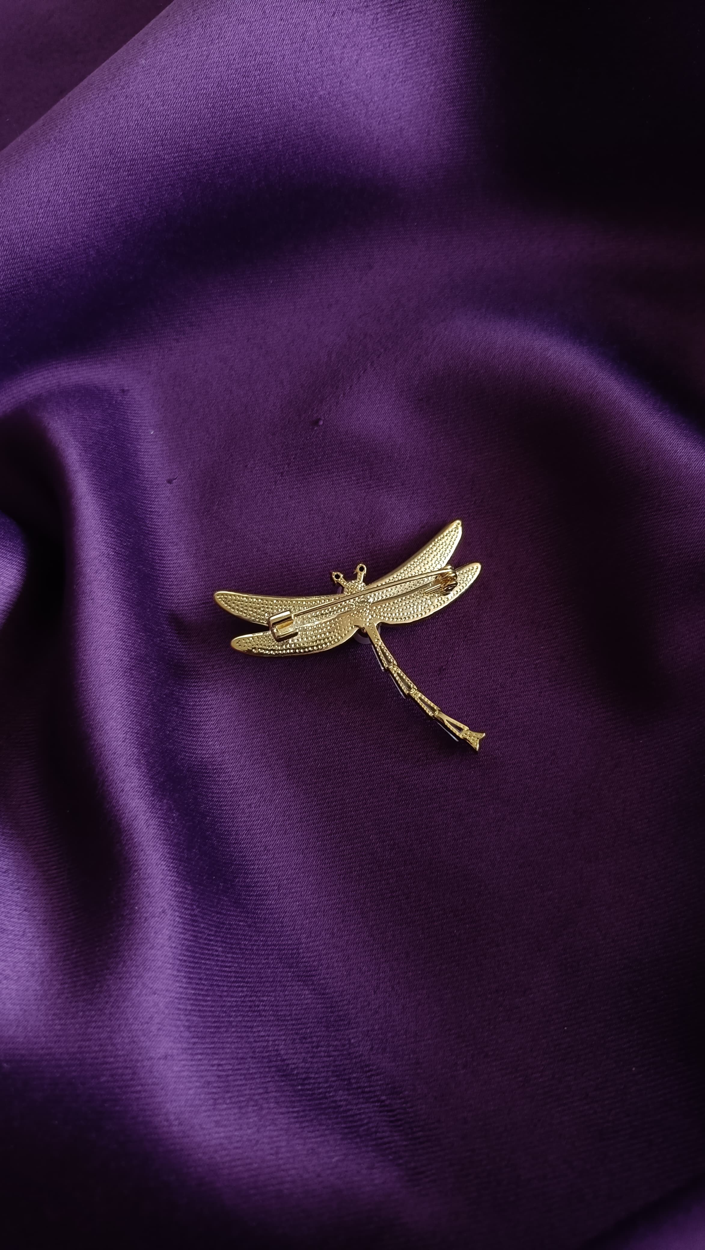 Gold Mother-of-Pearl Wing Dragonfly & Pearl Body Lapel Brooch Pin reverse side flat lay on purple fabric showing gold wing backs and pin back closure