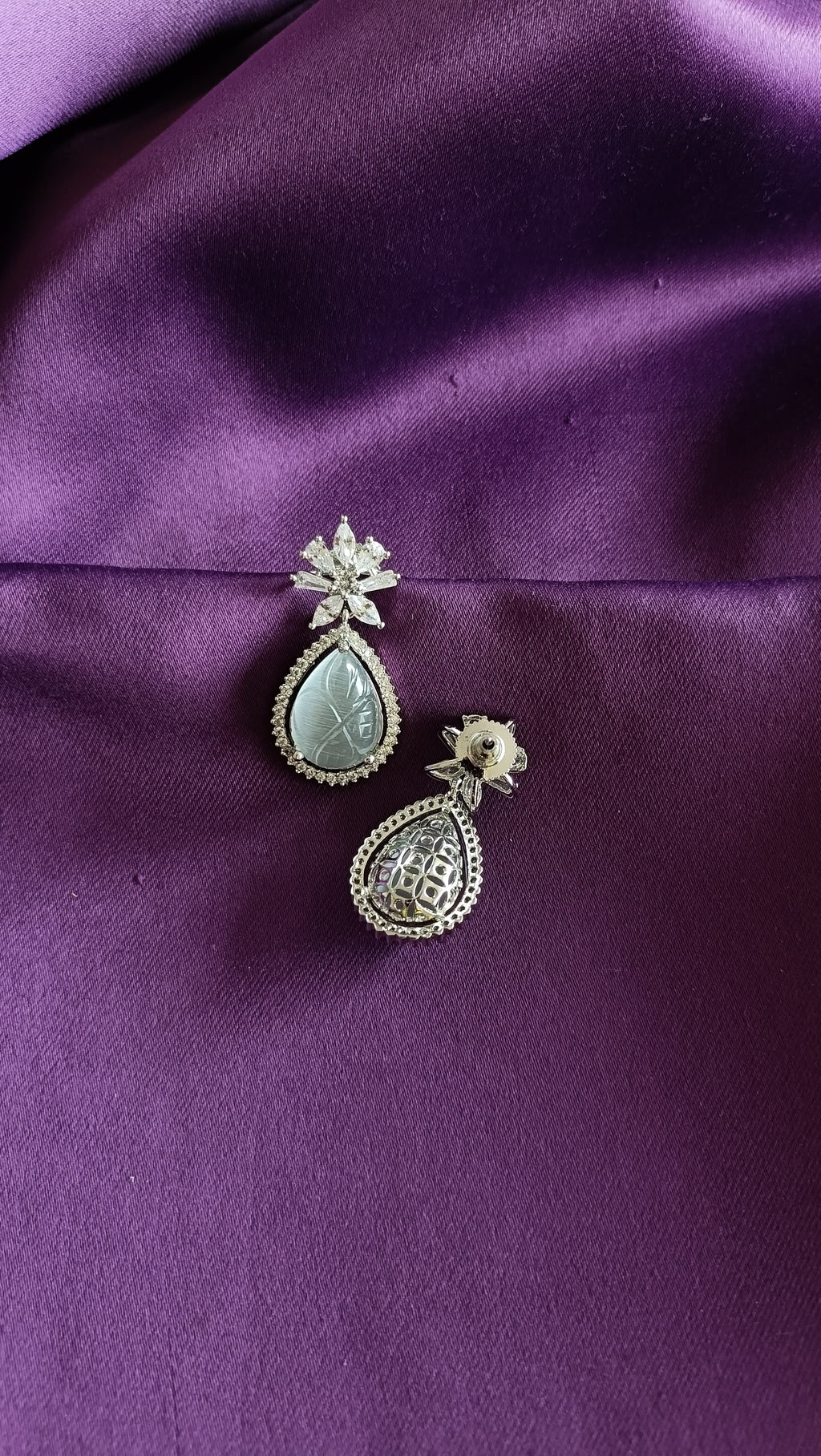 Silver Carved Jade Pear-Drop & Marquise Crystal Flower Drop Earrings front and back flat lay on purple fabric