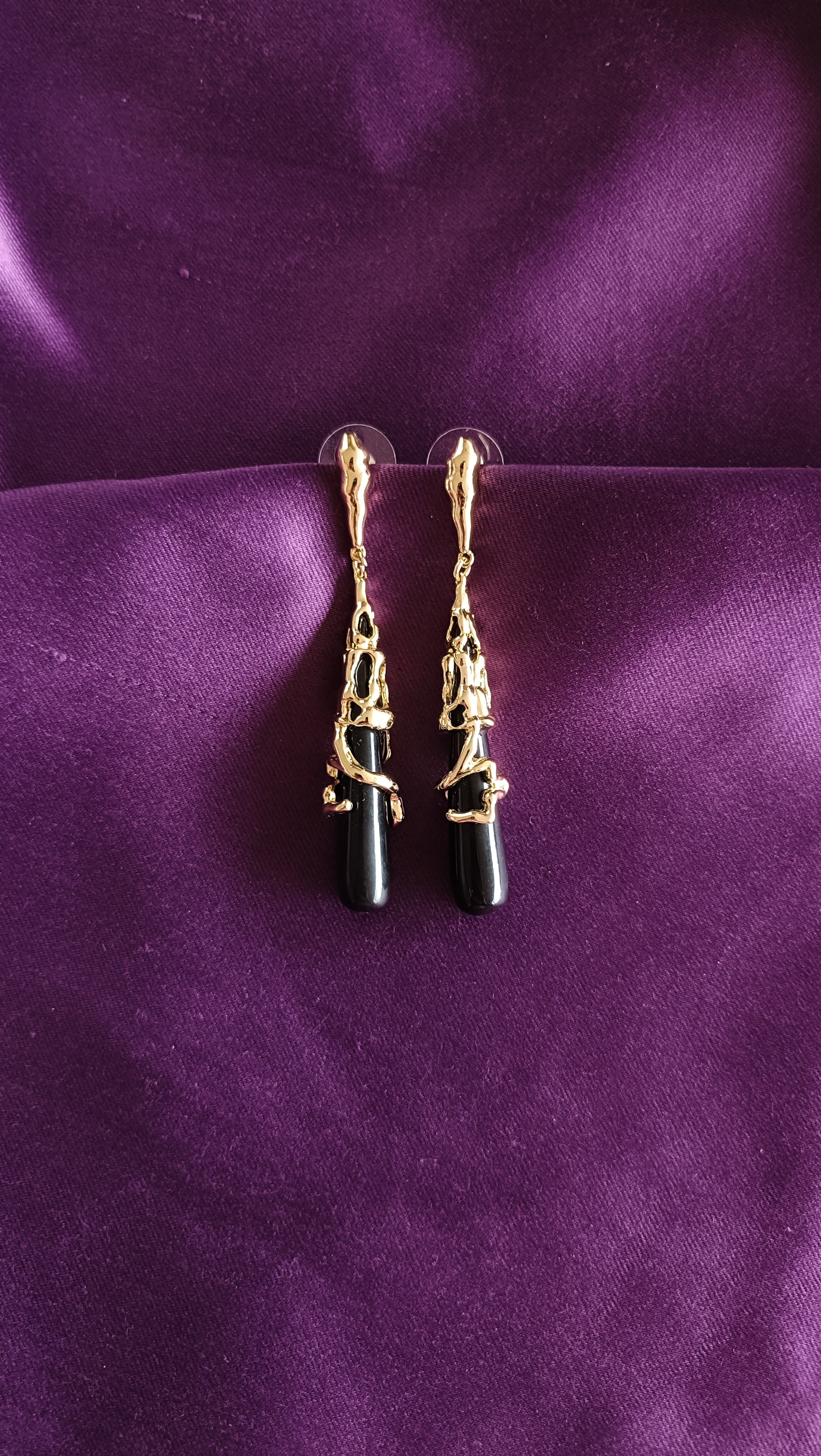 Gold Molten Sculptural Black Onyx Drop Earrings pair flat lay on purple fabric