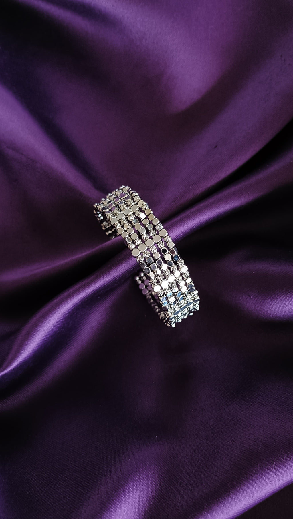 Silver Multi-Strand Sequin Disc Cuff Bracelet top view flat lay on purple fabric