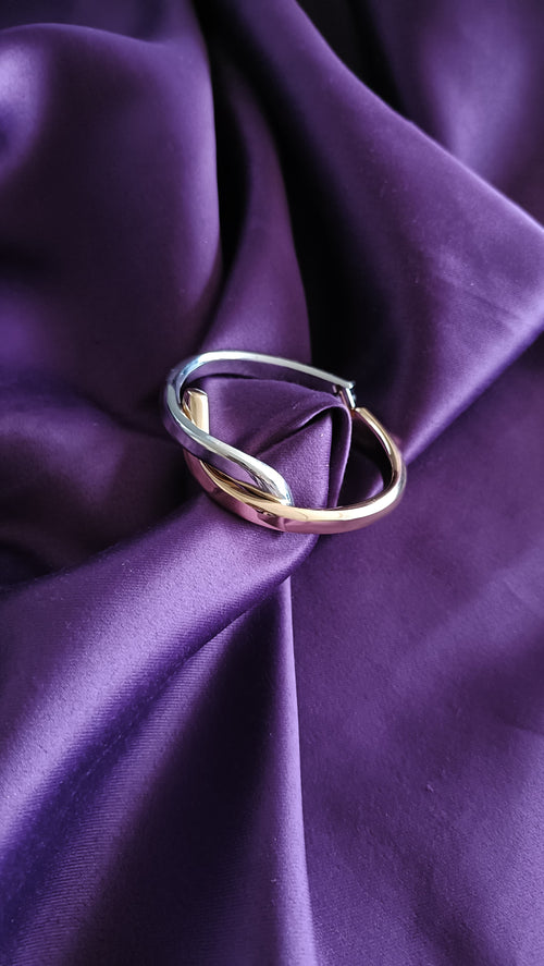 Bi-Tone Interlocking Oval Bangle Set silver-side flat lay on purple fabric