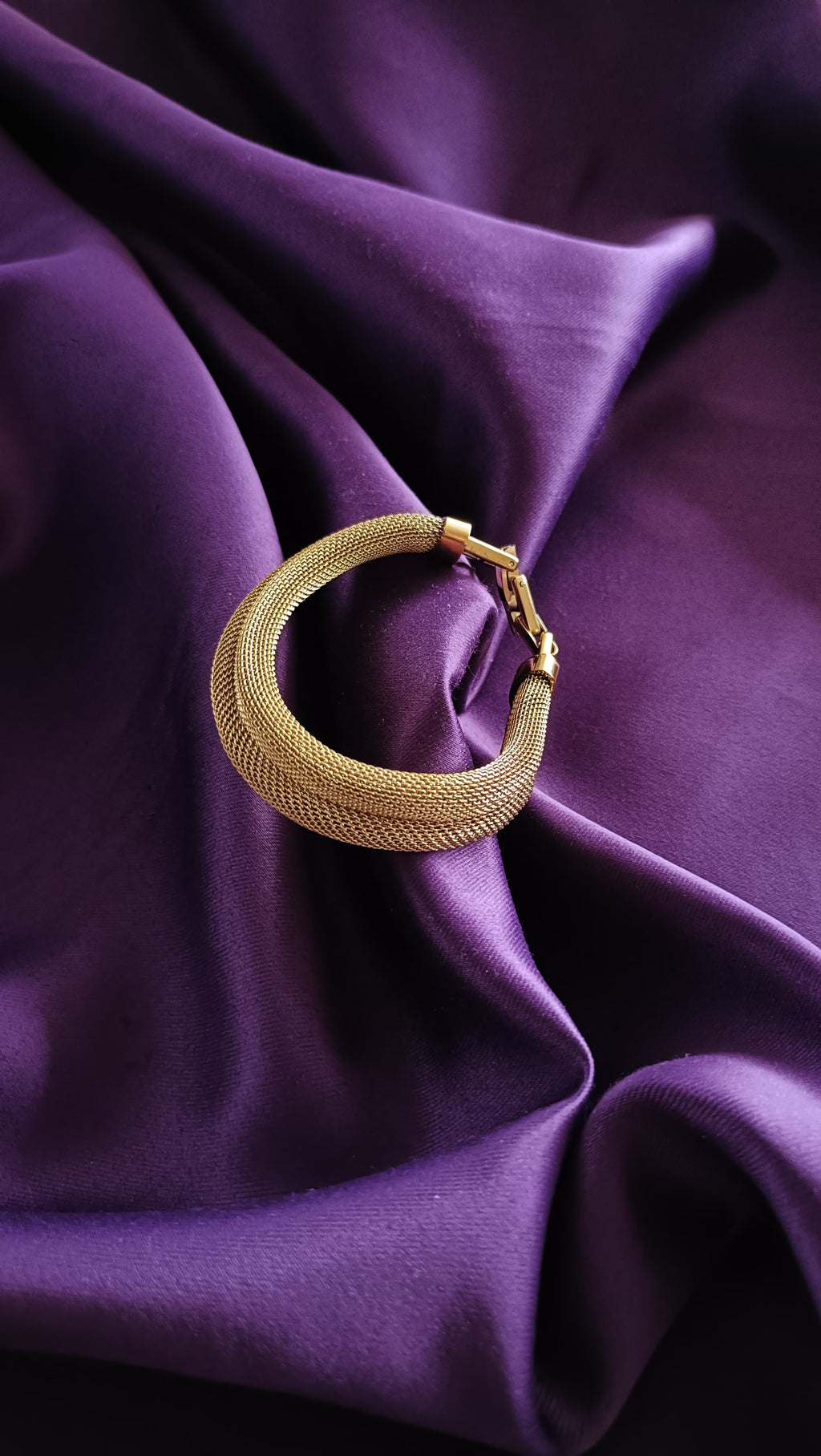 Gold Wide Mesh Tube Bangle Bracelet clasp detail flat lay on purple fabric