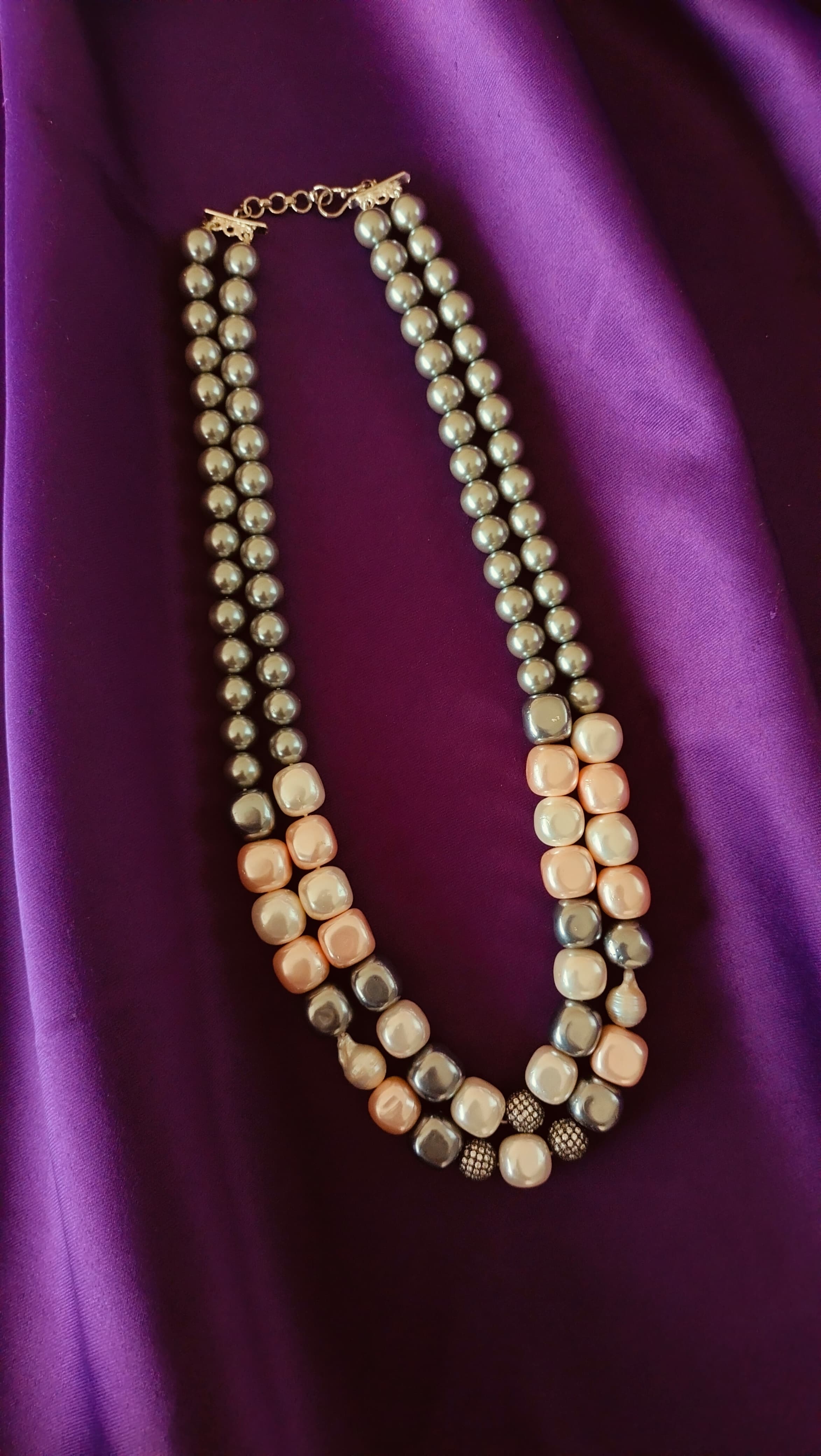 Double-Strand Graduated Grey & Blush Baroque Pearl Necklace full flat lay on purple fabric showing both strands and graduation